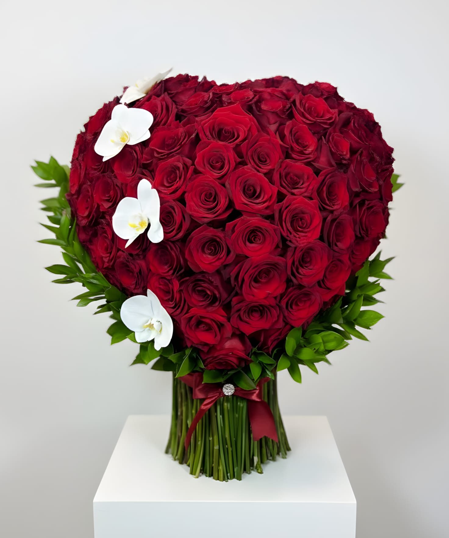 Heart-shaped bouquet of red roses with white orchids