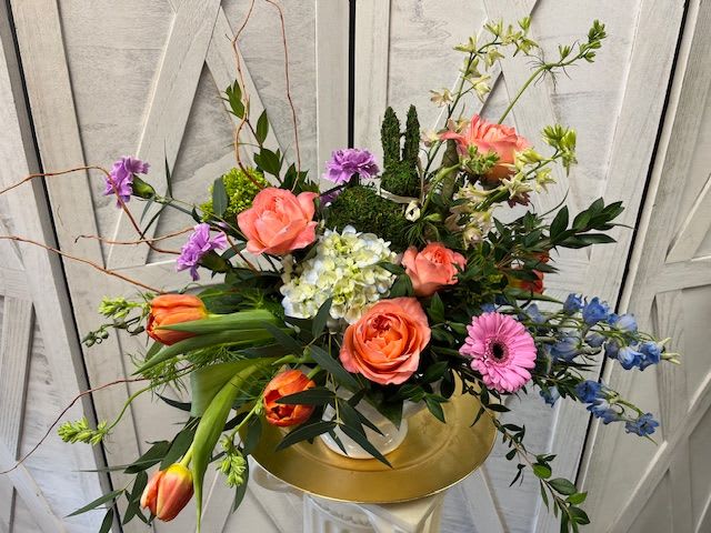 Spring Willow - A modern twist to the traditional Easter arrangement. Spring Willow is designed in a ceramic pedestal and is adorned by a sweet rabbit. Bring Springtime vibes into the home of the recipient.