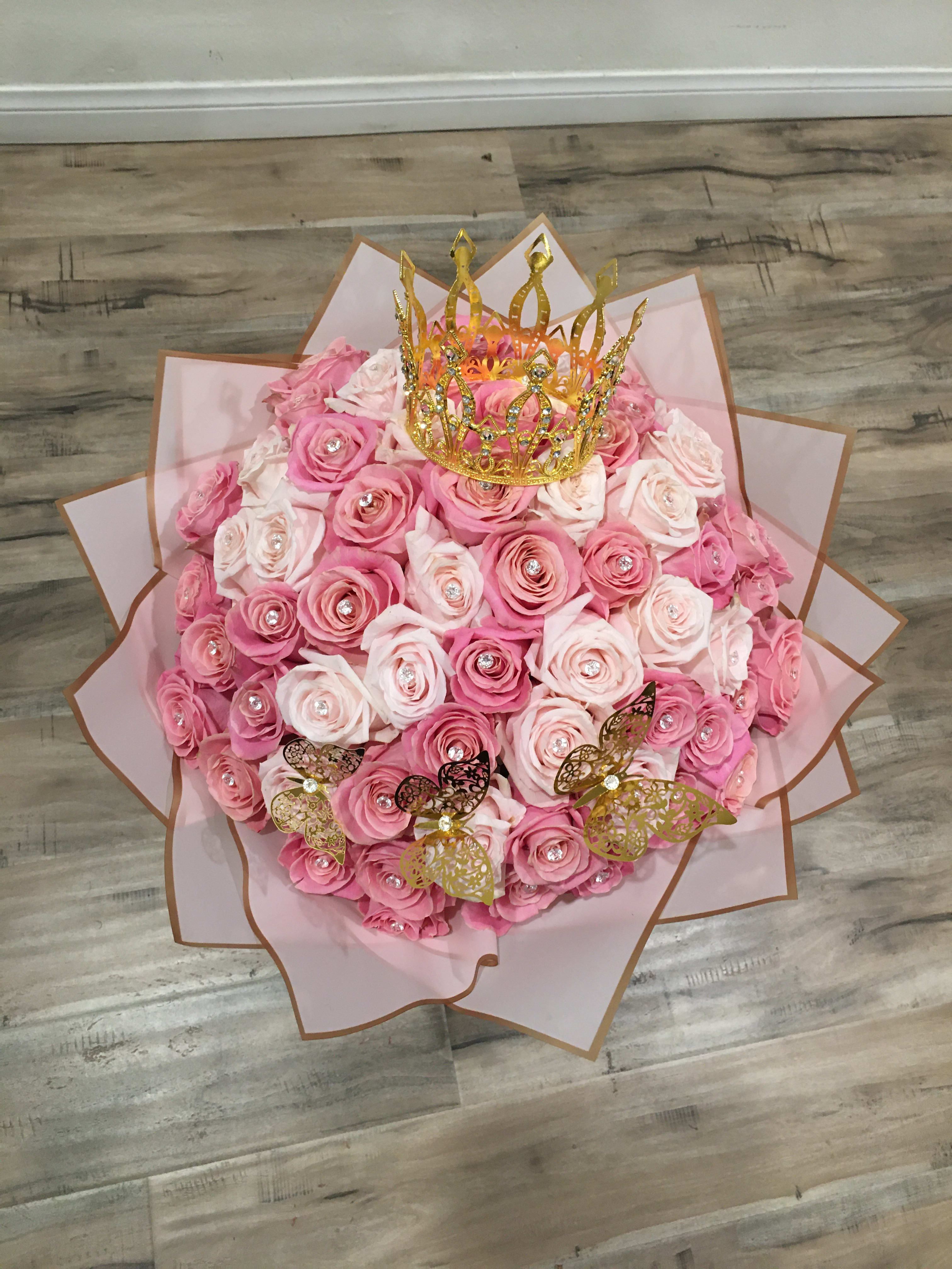 Pink rose bouquet with a gold crown topper and butterfly accents