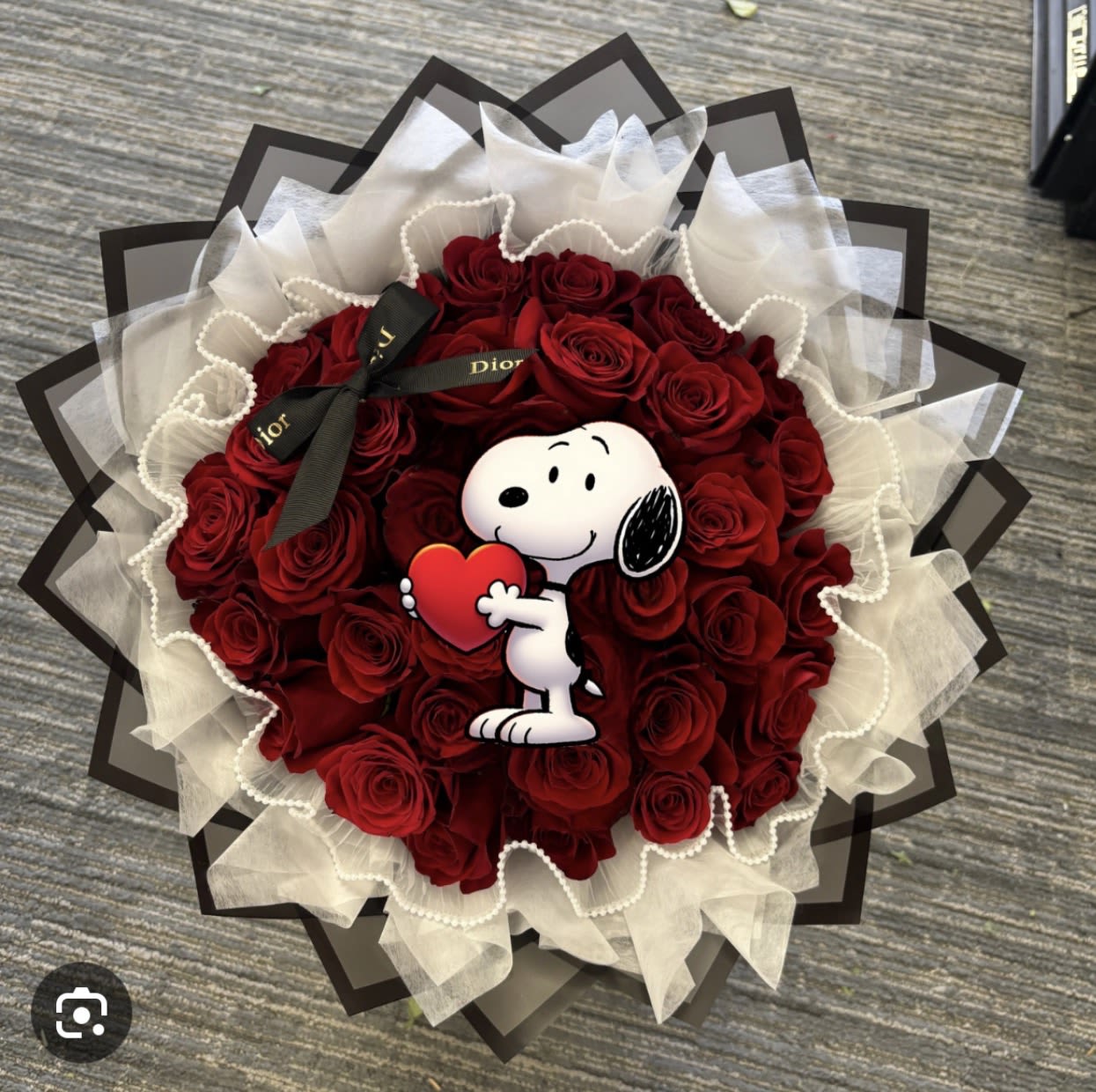 Bouquet of red roses with a Snoopy heart topper and black ribbon