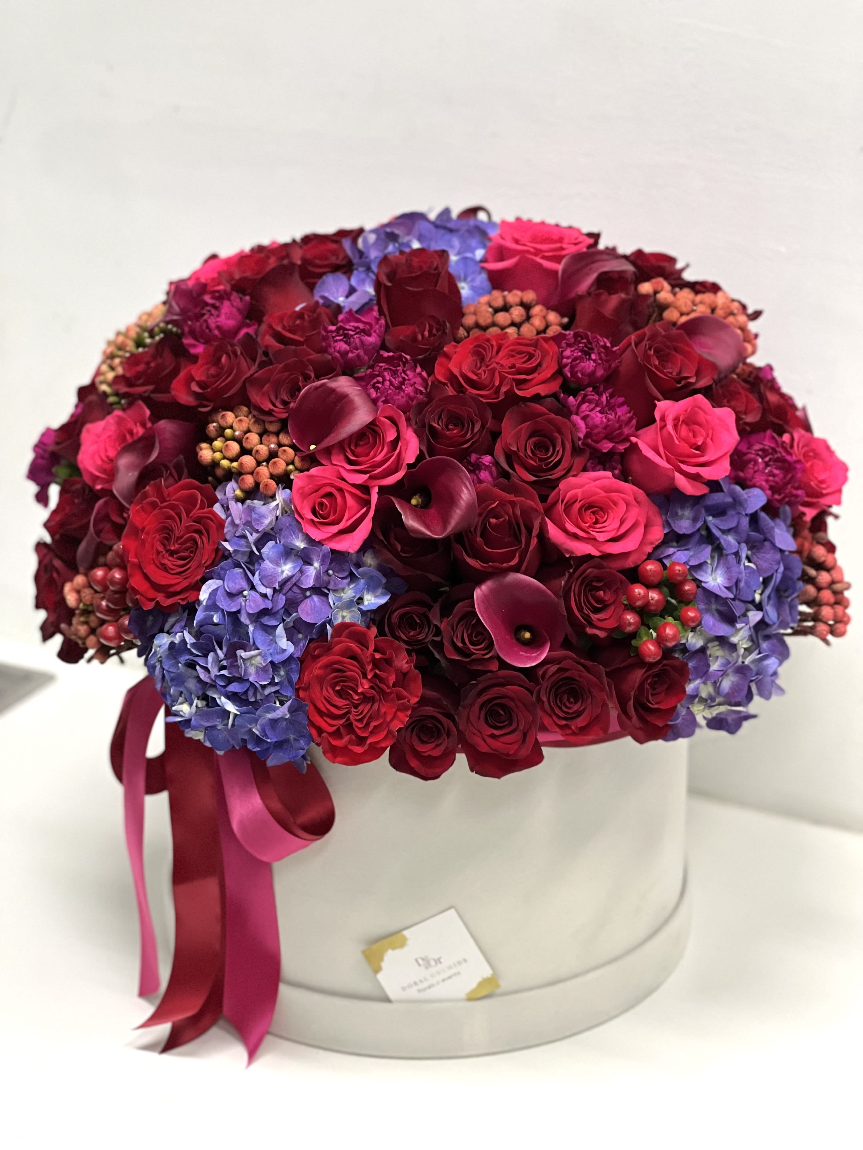 Fall in Love ™ - Magnificent blooms arranged in a large velvet hat box. Very trendy arrangement good for any occasion. 