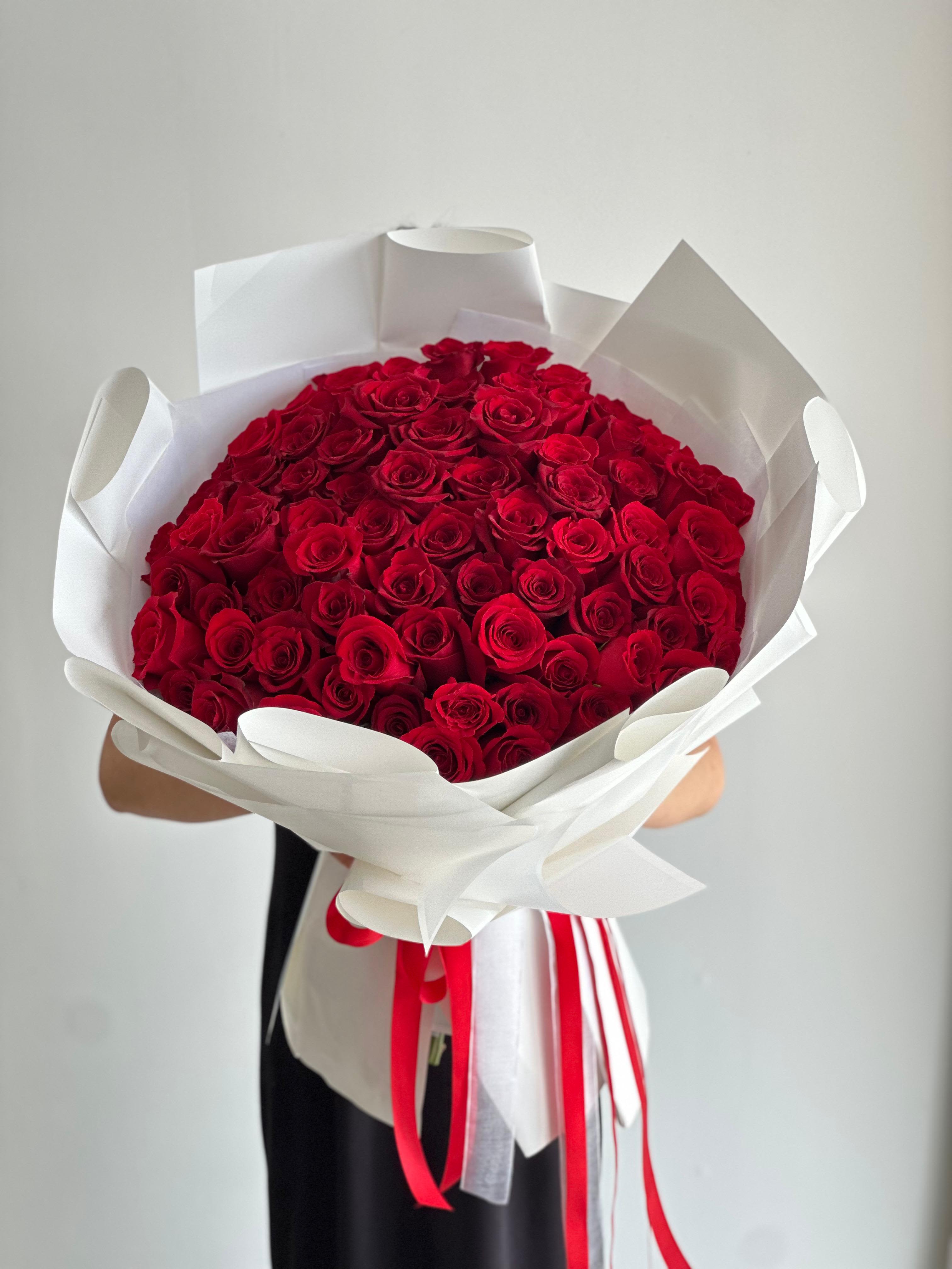 100 Red Roses - A bouquet of 100 fresh red roses, neatly wrapped in white paper. Other colors available upon request.