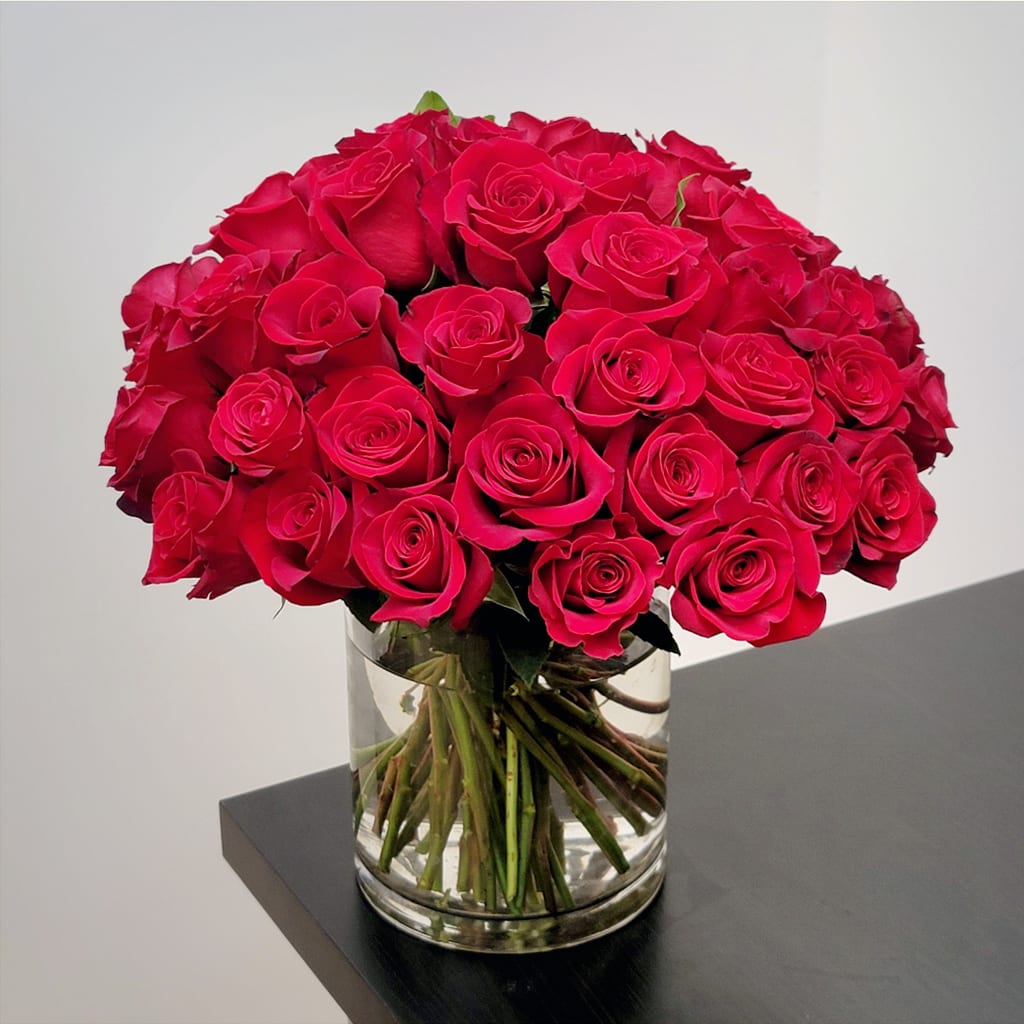 Valentine’s Rose Bouquet - Make a grand romantic gesture with this stunning bouquet of premium red roses, hand-crafted in a clear cylinder vase. Elegant, bold, and full of love, it's the perfect way to say "I love you."  Approximately 18" H x 17" W  Available in three sizes: - Standard: 40 premium red roses - Deluxe: 50 premium red roses - Premium: 60 premium red roses 