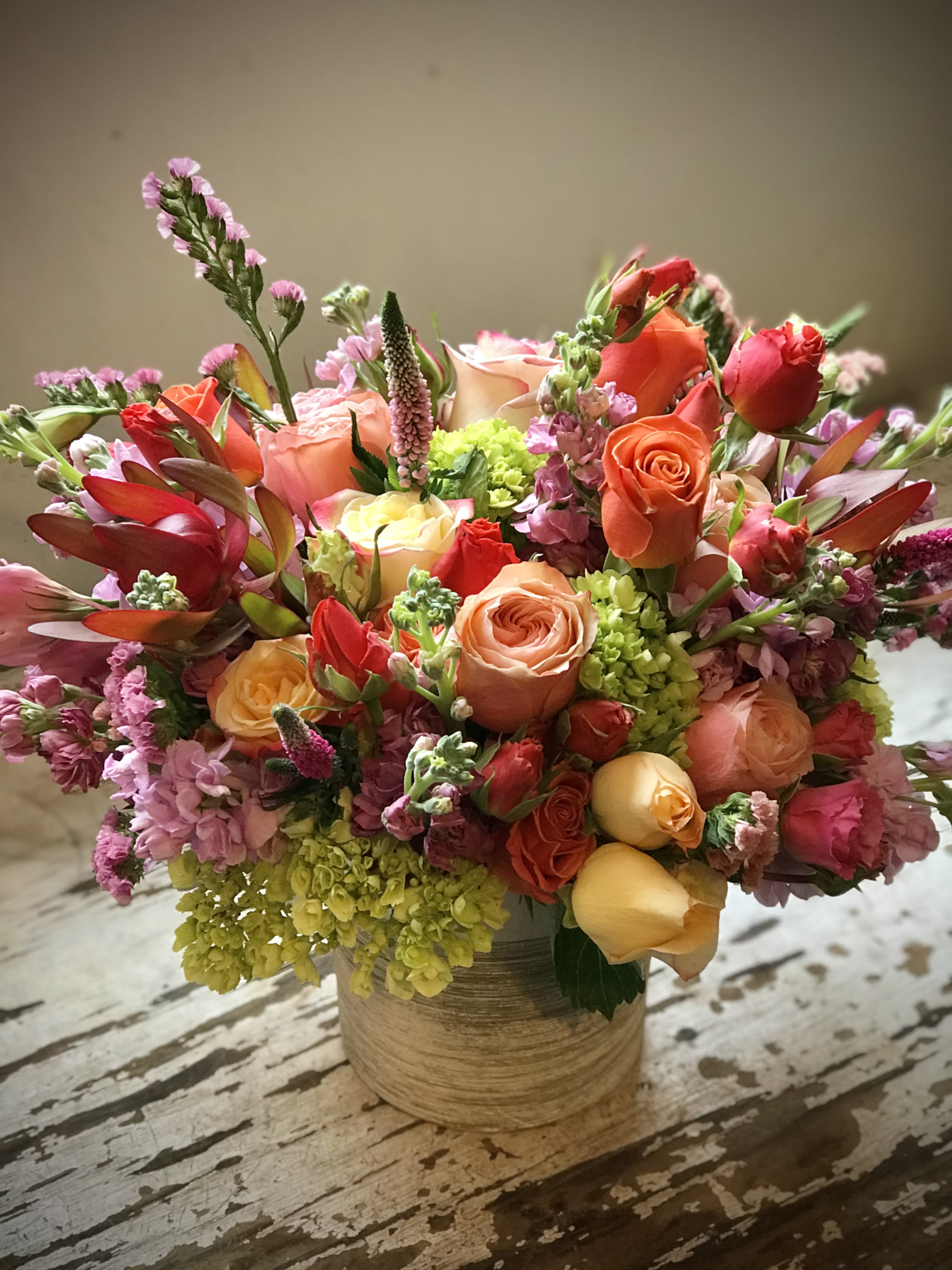 Go For It - Bursting with color and texture, this mixed arrangement is gathered in a modern white ceramic vase to bring life to any room.