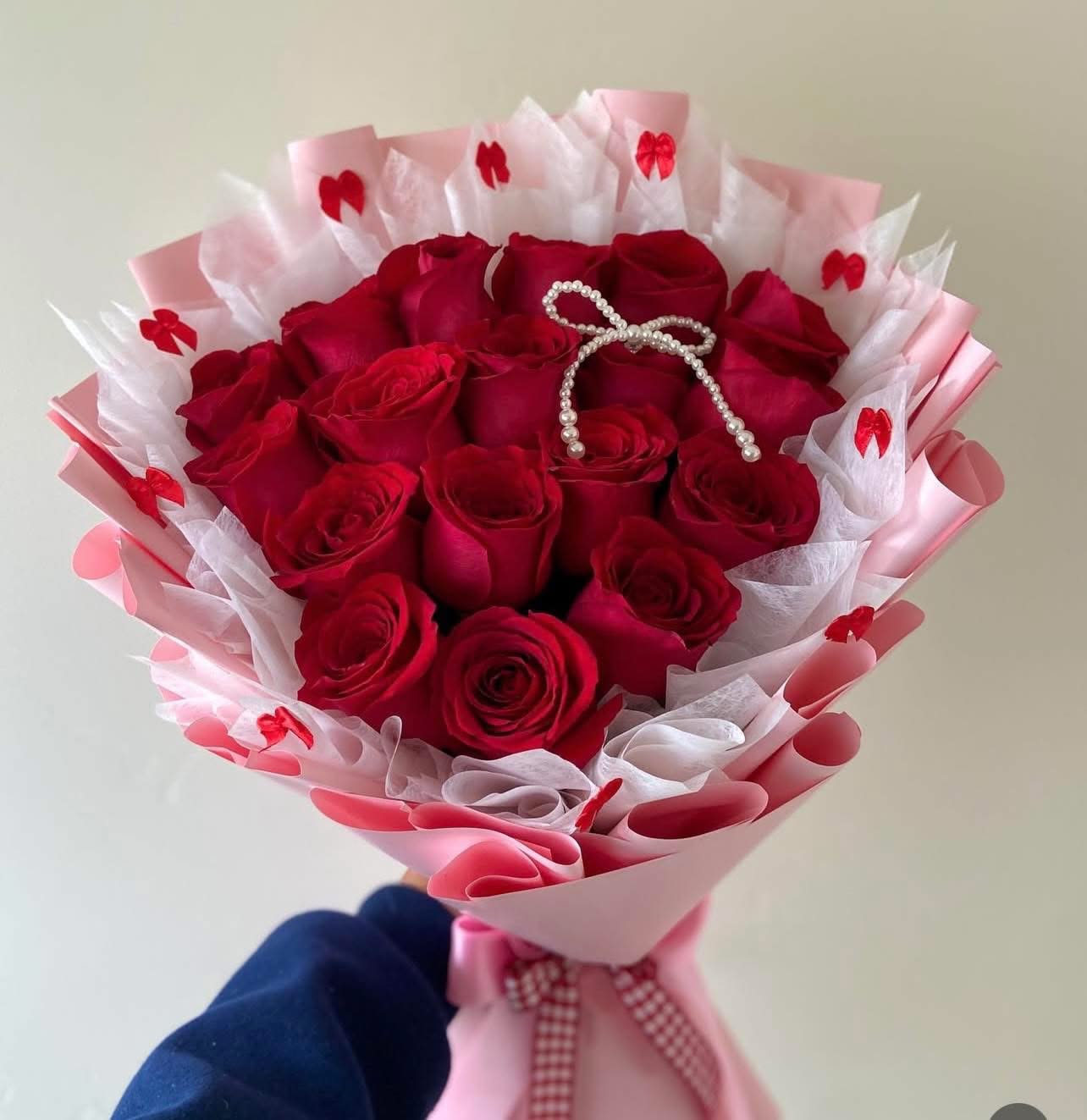 Sweetheart Bouquet - Make a bold and timeless statement with our stunning arrangement of 18 premium red roses. Each rose is carefully selected for its rich color, velvety petals, and long-lasting freshness. Beautifully wrapped in elegant pink and white layered paper and finished with delicate decorative accents, this bouquet is designed to impress from every angle.  Symbolizing love, passion, and admiration, 18 red roses make the perfect gift for anniversaries, birthdays, Valentine’s Day, or any special moment when words are not enough.
