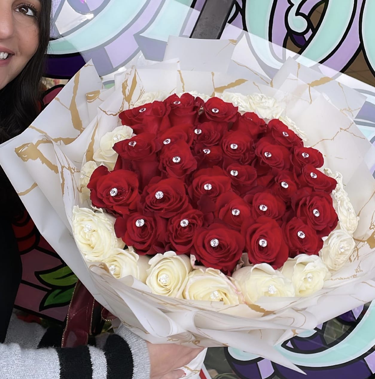 I love you bouquet - Introducing our exquisite bouquet of red and white roses, the perfect gift to express love and admiration. This stunning arrangement, held gracefully by a woman, captures the essence of elegance and romance. The vibrant red roses symbolize passion and desire, while the pure white roses represent purity and innocence. Handcrafted with care, this bouquet is sure to make a lasting impression on any recipient. Whether it's a special occasion or just to brighten someone's day, our bouquet of red and white roses is a timeless choice that will never go out of style.