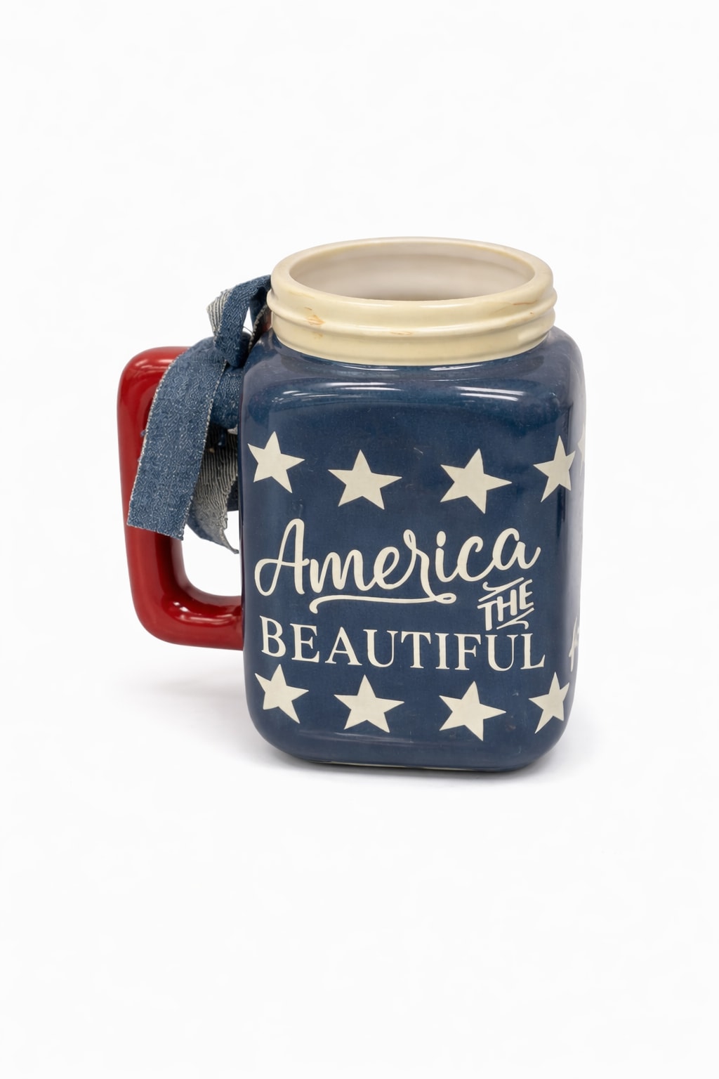 America the Beautiful Mason Jar Mug - A patriotic mason jar-style mug featuring the phrase "America the Beautiful" surrounded by white stars on a deep blue background. Complete with a red handle and a blue ribbon, it's a charming piece for festive decor. 