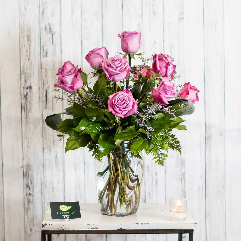 Aroma - A dozen fragrant lavender roses arranged in a vase with textural greens and petite filler blooms.  Approximate Dimensions: 26"H x 18"W