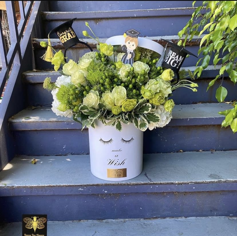 Congrats Grad - Buzzy Bee Flowers  - This beautiful arrangement is designed to deliver happiness to a loved ones day. Intended for a graduate it is Filled with beautiful flowers and customized to perfection, this arrangement is a showstopper! If you want to turn heads then this is the arrangement for you!