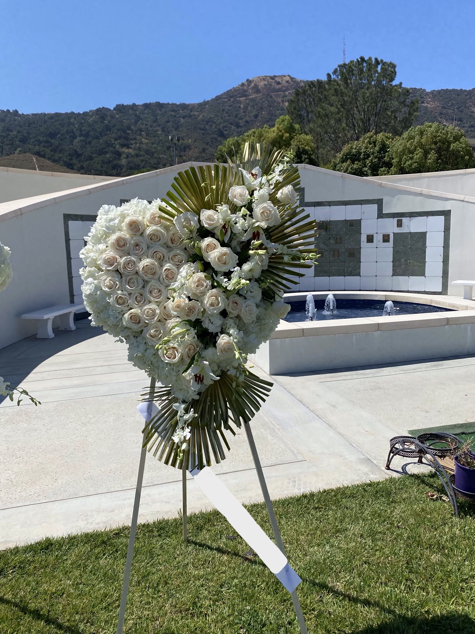White Clouds -  Santa Clarita Valley Florist - An all white tribute, this white Heart funeral spray is pure and tranquil. Featuring a variety of white flowers, this elegant easel compliments the beauty of life.