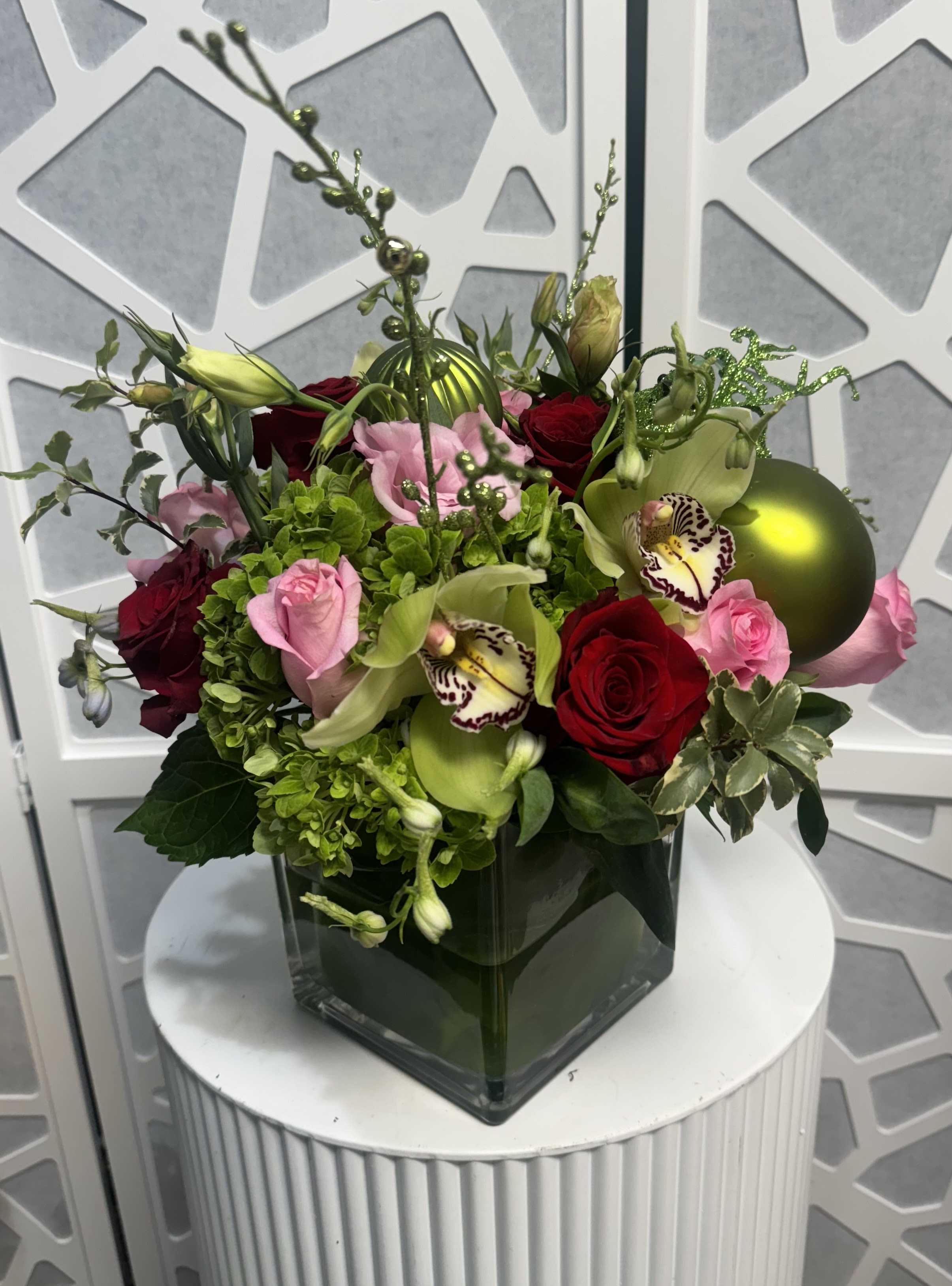 Holiday Elegance - Santa Clarita Valley Florist  - Celebrate the season with the festive cheer of the Holiday Fun arrangement! This joyful bouquet combines the timeless beauty of velvety red roses with the sparkle of holiday ornaments, nestled among lush seasonal greens. Accented with pops of wintry textures like holly, pinecones, or frosted leaves, this arrangement brings warmth and elegance to any holiday décor. Perfect as a centerpiece or gift, it captures the magic of the holidays in every vibrant petal and shimmering detail.  