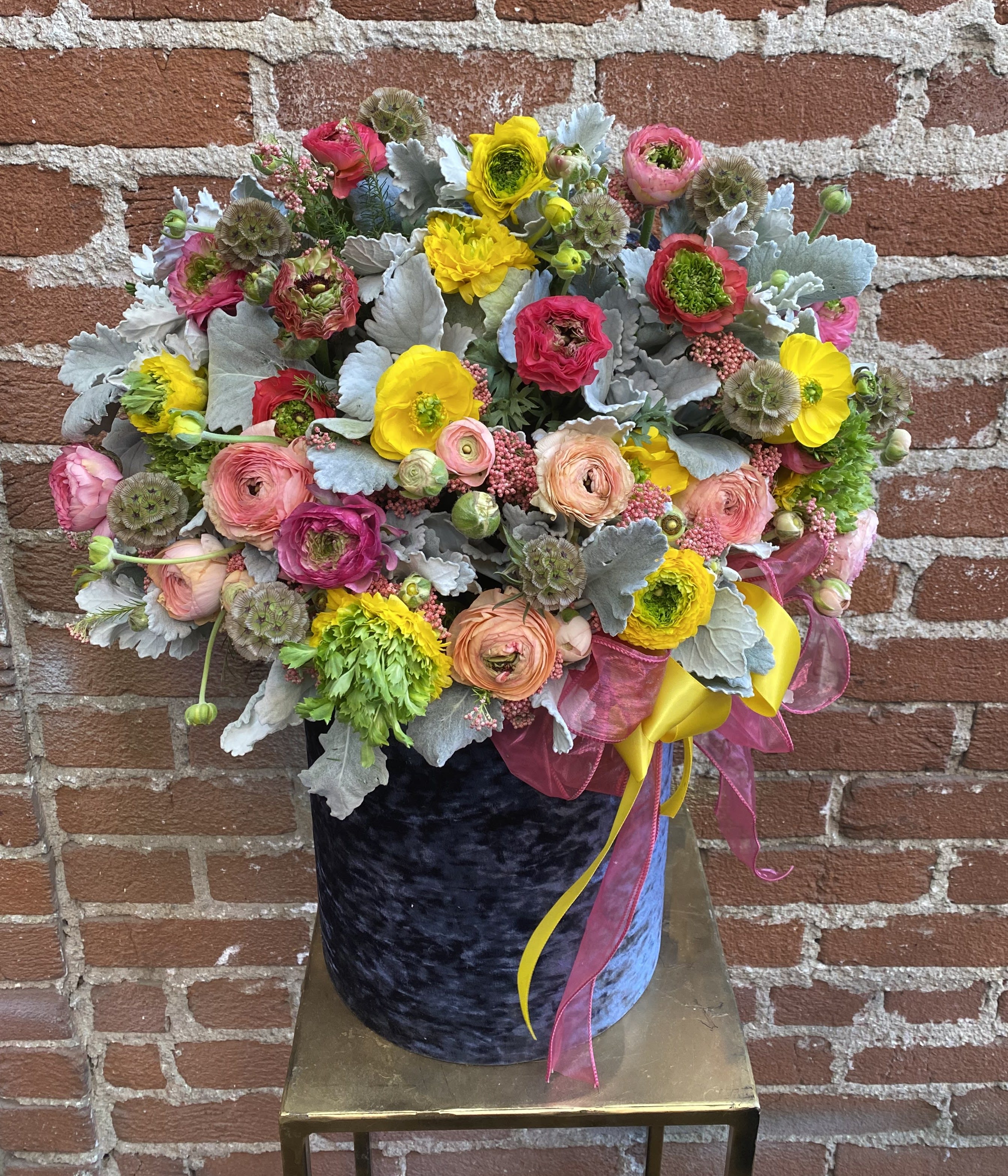 Midnight Glaze -  Santa Clarita Valley Florist - Prepare to be swept away by the enchanting allure of our "Midnight Glaze" floral arrangement. This captivating composition draws inspiration from the velvety darkness of midnight skies and the alluring glimmer of moonlight, resulting in a breathtaking display that encapsulates mystery, elegance, and a touch of celestial magic. "Midnight Glaze" is more than a floral arrangement; it's a tribute to the captivating beauty of the cosmos. Its blend of deep colors, glimmering accents, and enchanting blooms come together to create a visual masterpiece that pays homage to the mysteries that unfold under the cover of night. Let "Midnight Glaze" be your conduit to the awe and wonder inspired by the night sky, reminding you of the beauty that lies beyond the stars. 