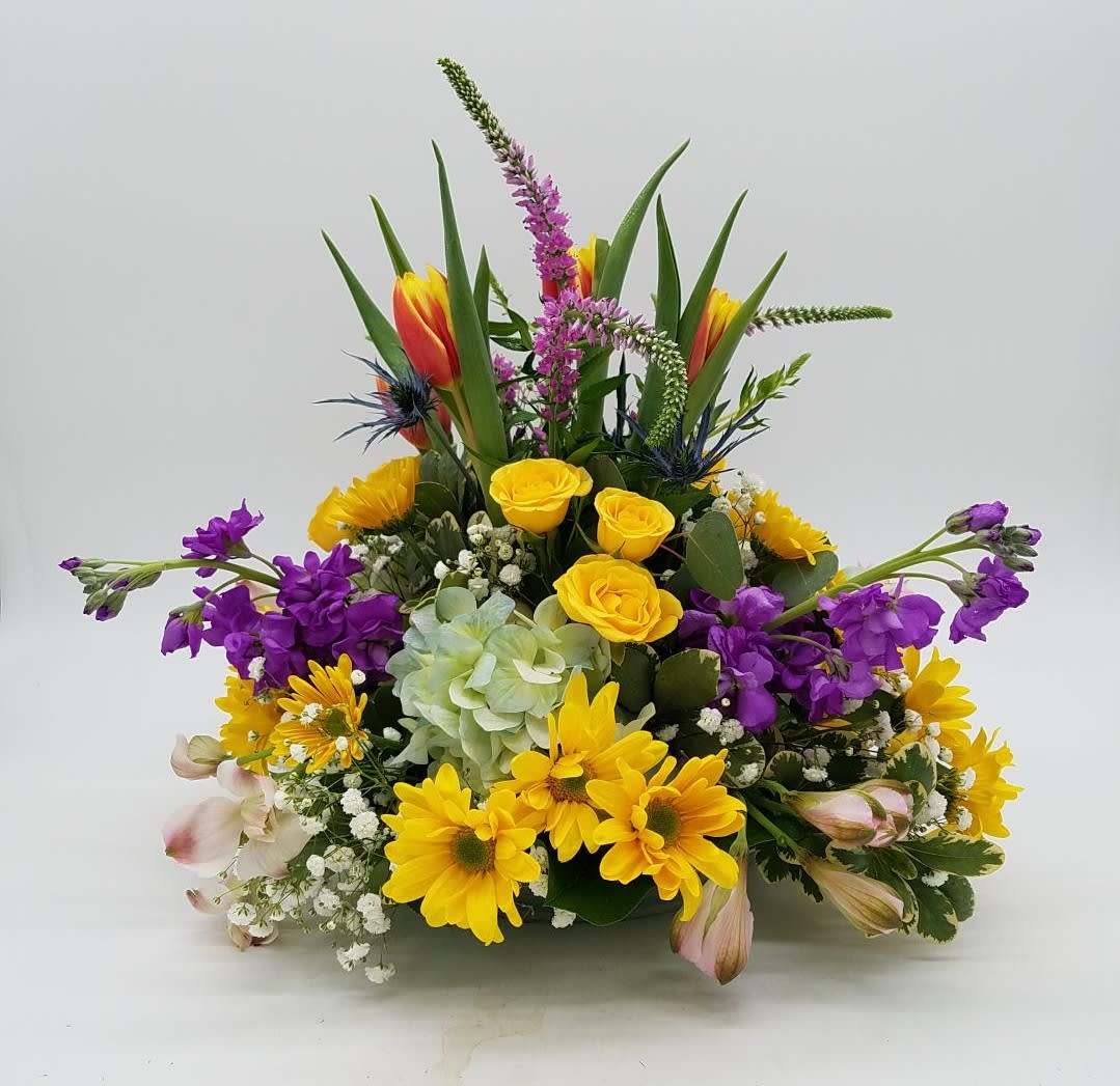 The Spring Garden Centerpiece - A beautiful mix of spring blooms, arranged round and low for the perfect piece to put on your Easter or Passover table!