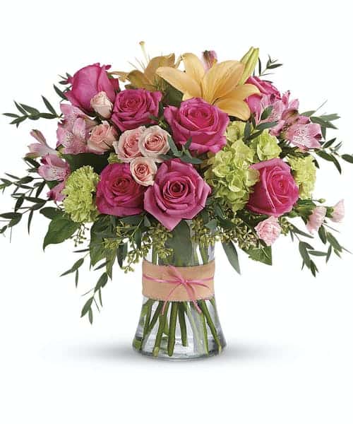 Pink and yellow flower bouquet in a clear glass vase
