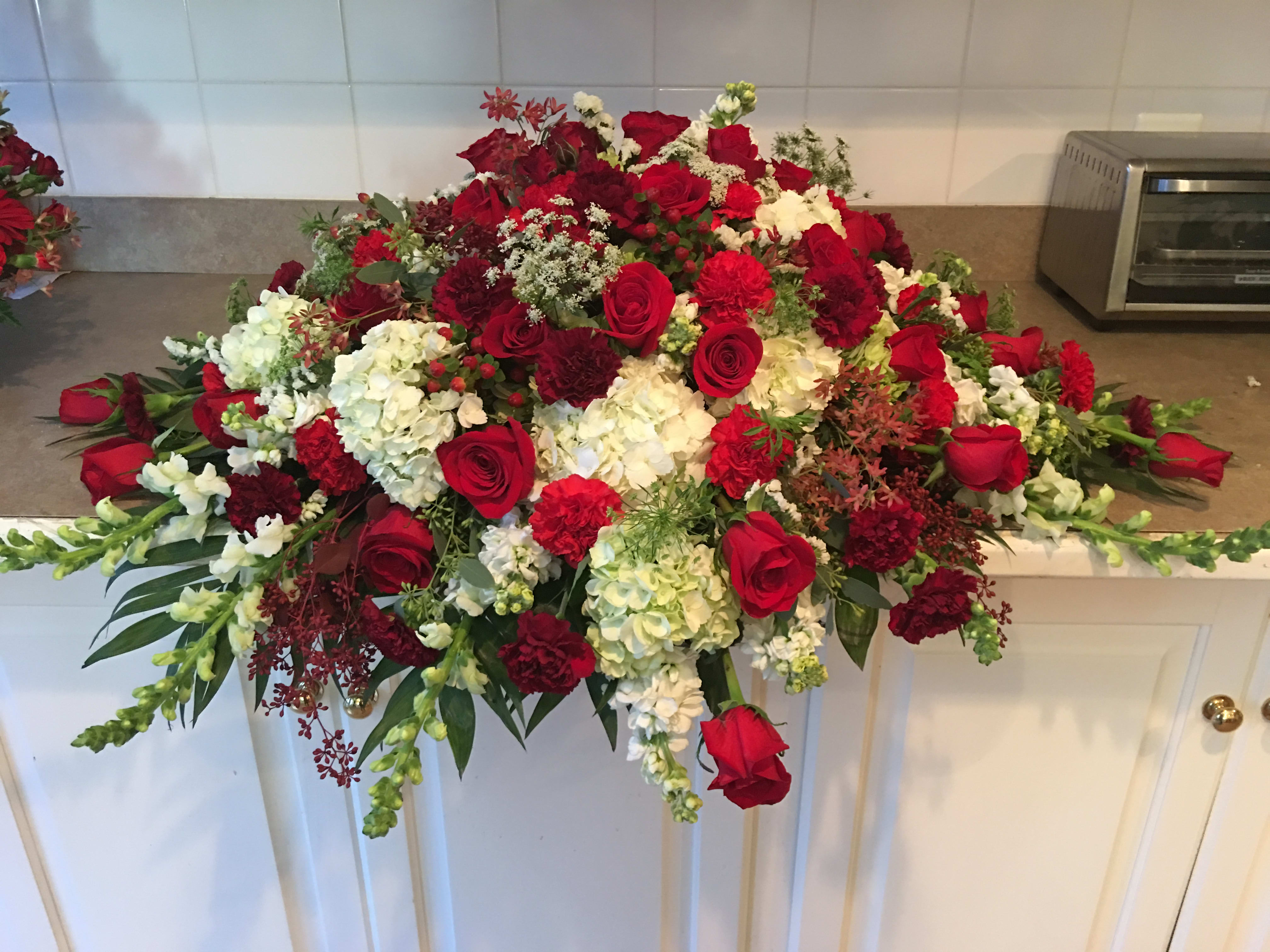 Large red and white floral arrangement with roses and carnations