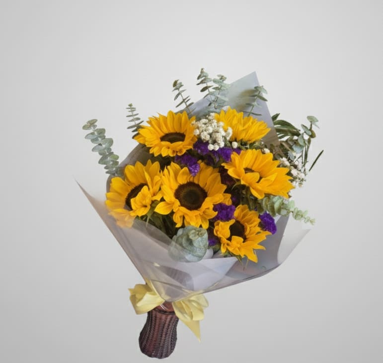 Golden Harvest - Celebrate life's abundance with the stunning Golden Harvest bouquet. Brilliant sunflowers take center stage, complemented by rich purple accents to create a vibrant, warm display. This arrangement is the perfect way to share happiness and mark any joyful occasion.