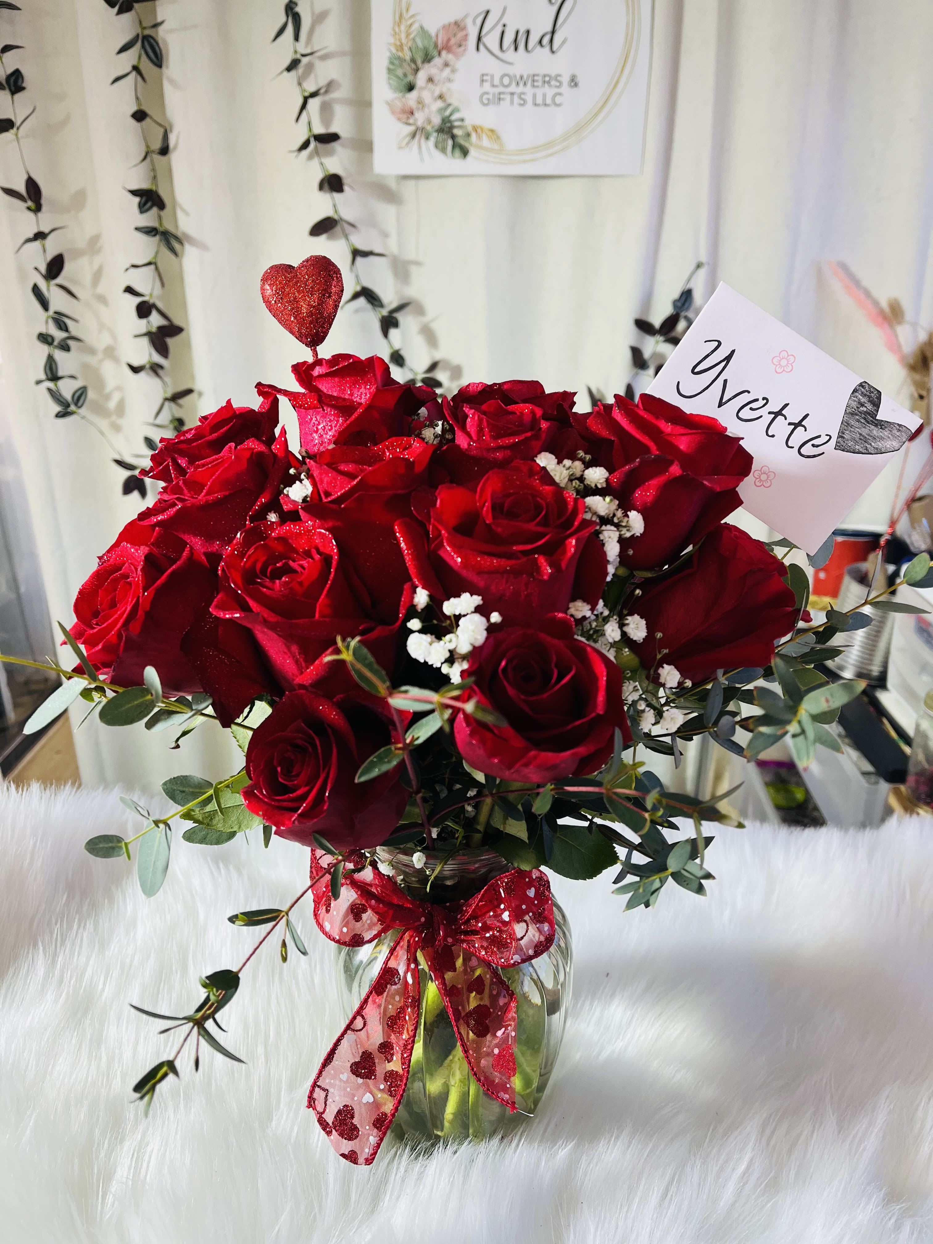 Passion  - Say “I Love you” in the most timeless way with our “Passion” arrangement — a stunning bouquet of fresh red roses accented with baby’s breath and greenery, all beautifully arranged in a clear glass vase with a festive ribbon.   Details: 	•	A dozen premium red roses 	•	Accents: Baby’s breath and eucalyptus greenery 	•	Glass vase with a romantic red bow and heart detail 	•	Includes a personalized note card   Perfect for Valentine’s Day, anniversaries, birthdays, or any moment of love