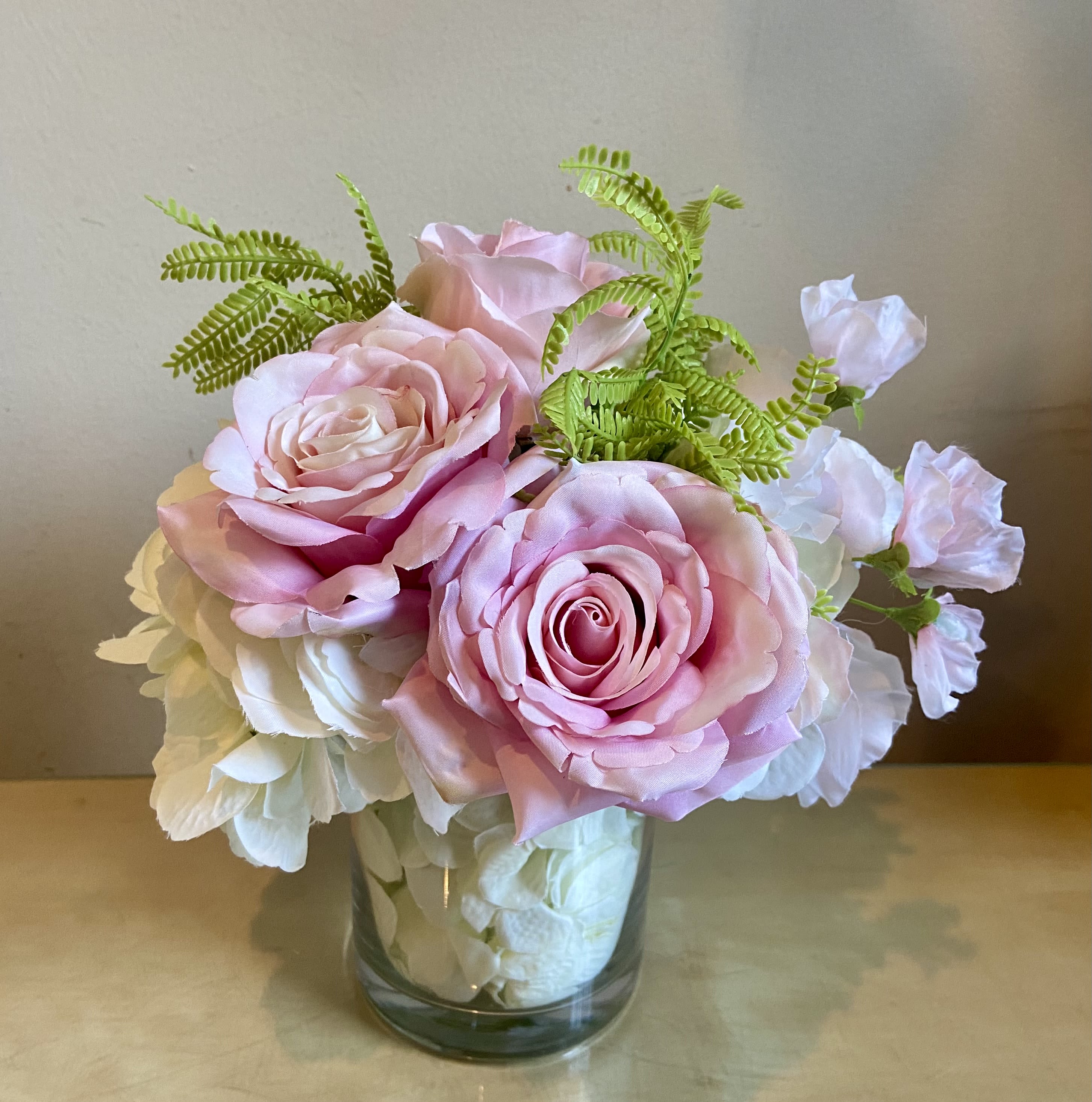 Garden Rose - Silk Floral Design - Exquisite Silk arrangement of garden roses, white hydrangea, sweet pea and fern accent. Designed in a clear glass vase with hydrangea blossoms in vase.