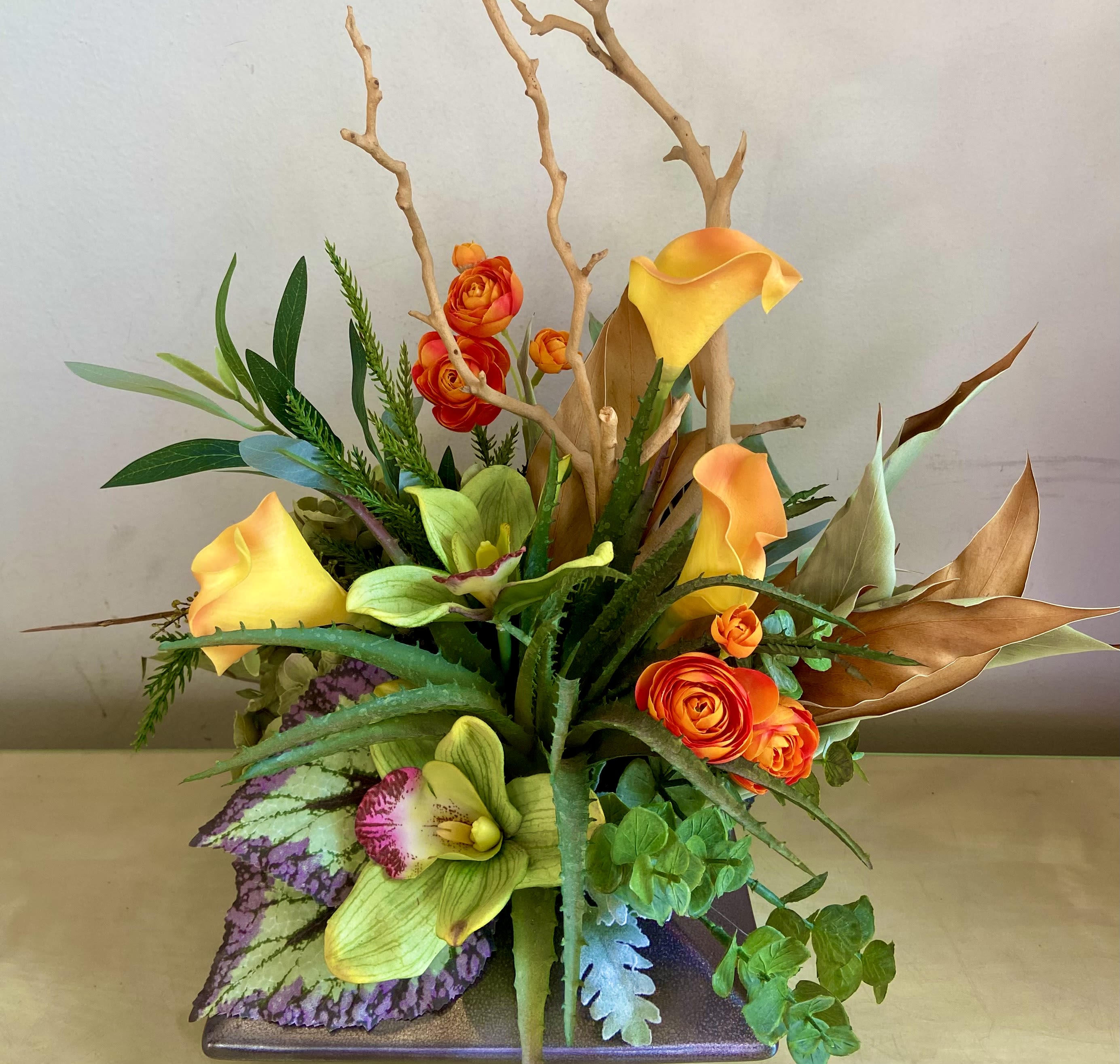 So Trendy - Silk Floral Design - So cool, so trendy!  Silk, dried and organic floral arrangement in low cerramic vase. Natural manzanita branch with succulent, callas, ranunculus, hydrangea, cymbidium orchid blossoms and more. 