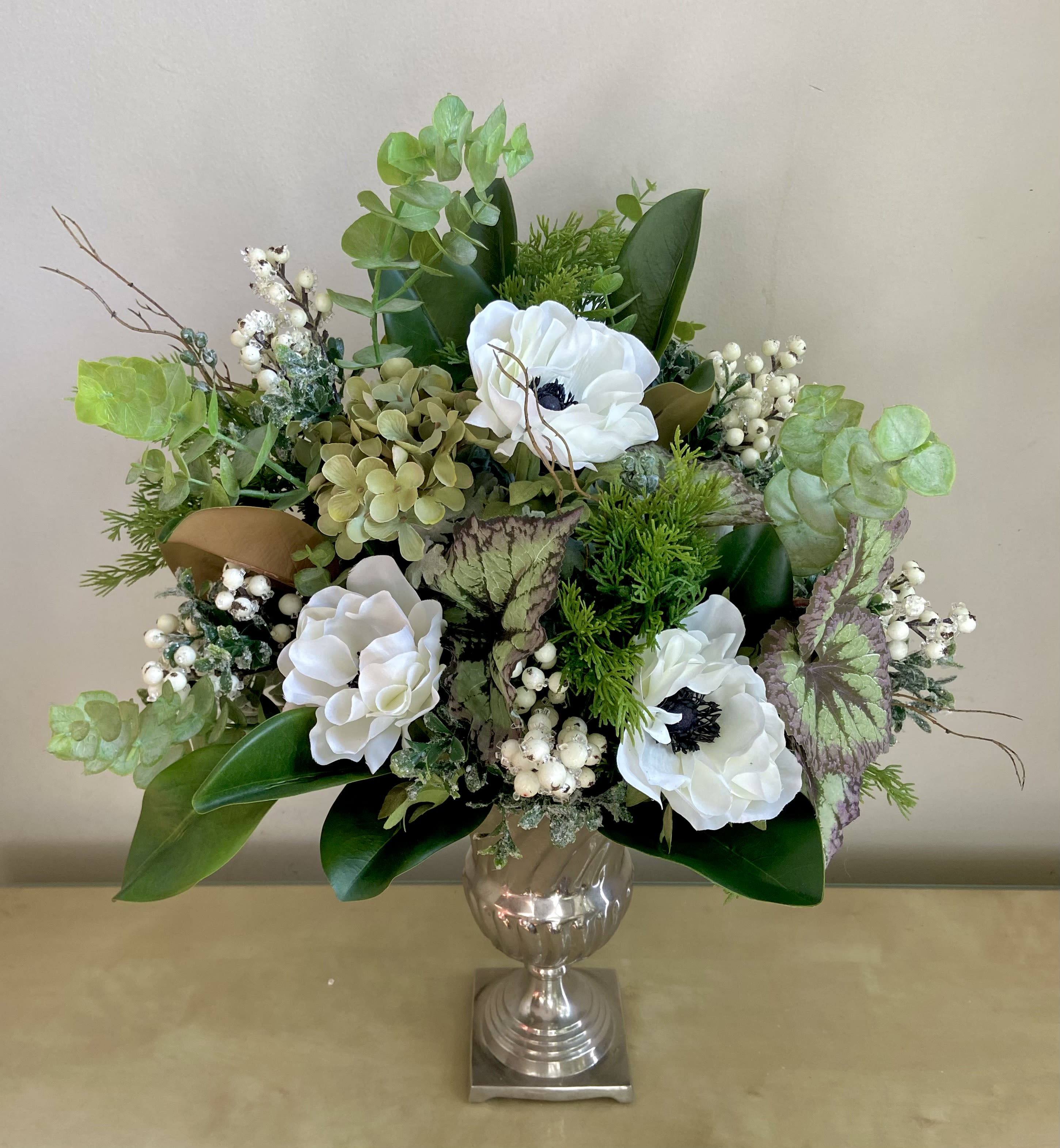 White Wonder - Silk Floral Design - Permanent white and green Silk arrangement in a Classic Silver Urn. High quality materials look natural &amp; beautiful always with no maintenance. Tall &amp; lush composition of hydrangea, anemones, eucalyptus, snow berries, greens &amp; more in a color scheme that works in any setting.  24” tall &amp; 16” wide.