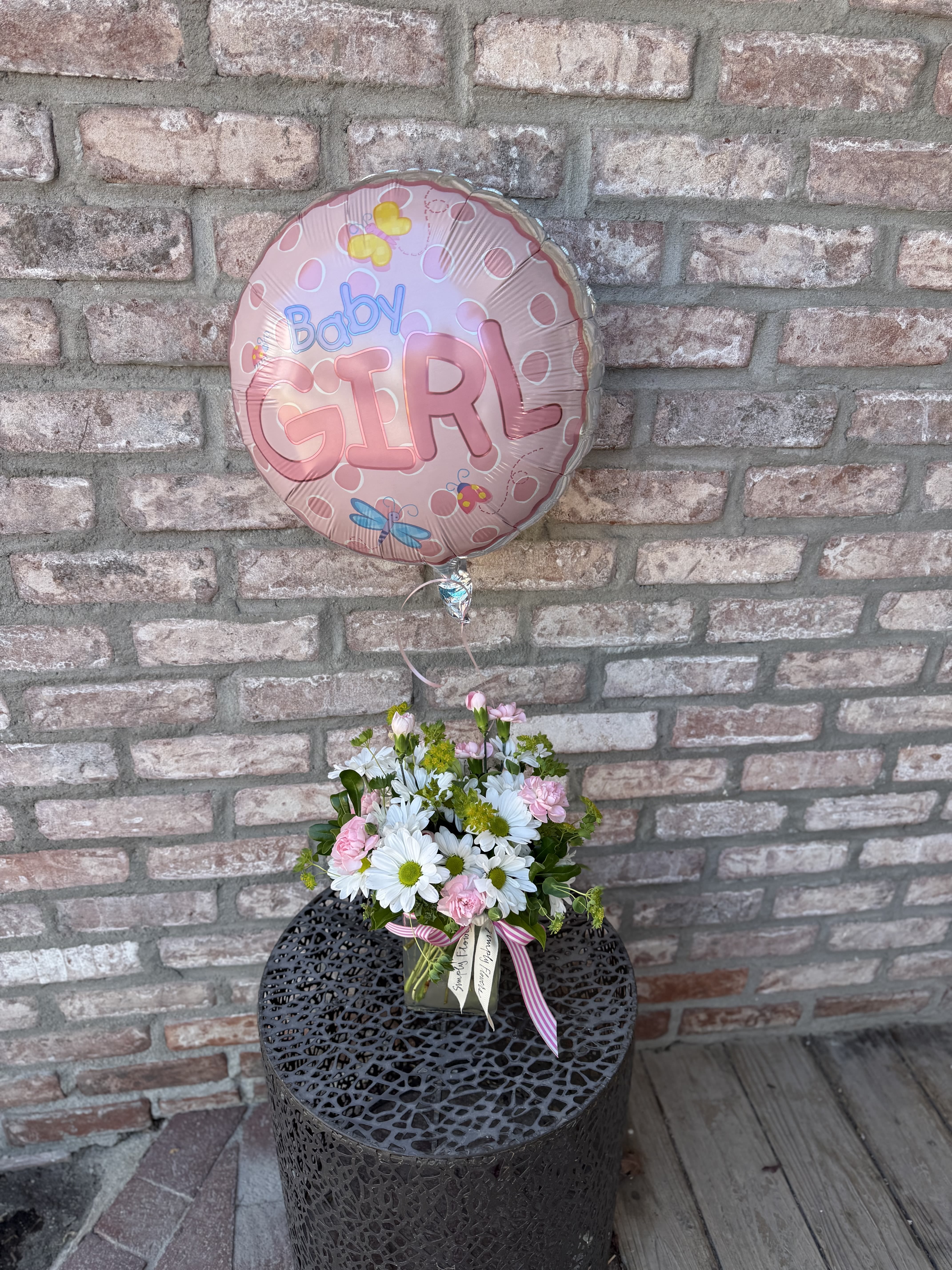 Baby Girl Bundle - Celebrate the life of a new baby girl With our darling bundle options! Arrangement is designed in a rectangular glass vase. Filled with sweet daisies and pink pixies. Deluxe and Premium also have garden spray roses added. Every option comes with a baby girl balloon, style may vary. See photos and descriptions for 