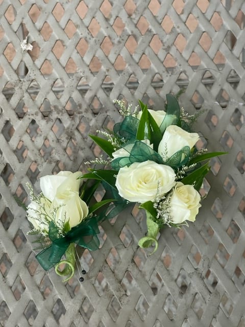  white Rose Corsage And Boutonniere set - White rose Corsage and Boutonniere (examples for customers) We pre-order over Florals with our growers two weeks in advance prior to a school dance. Select your color of ribbon of your choice. Keep in mind, these are examples from past years, we are not guarantee types of roses from our growers Corsage- $38.00 Boutonniere- $21.00 -Any add-ons such as delphinium, rhinestone, double ribbon or magnetic boutonnieres are subject to an addition fee