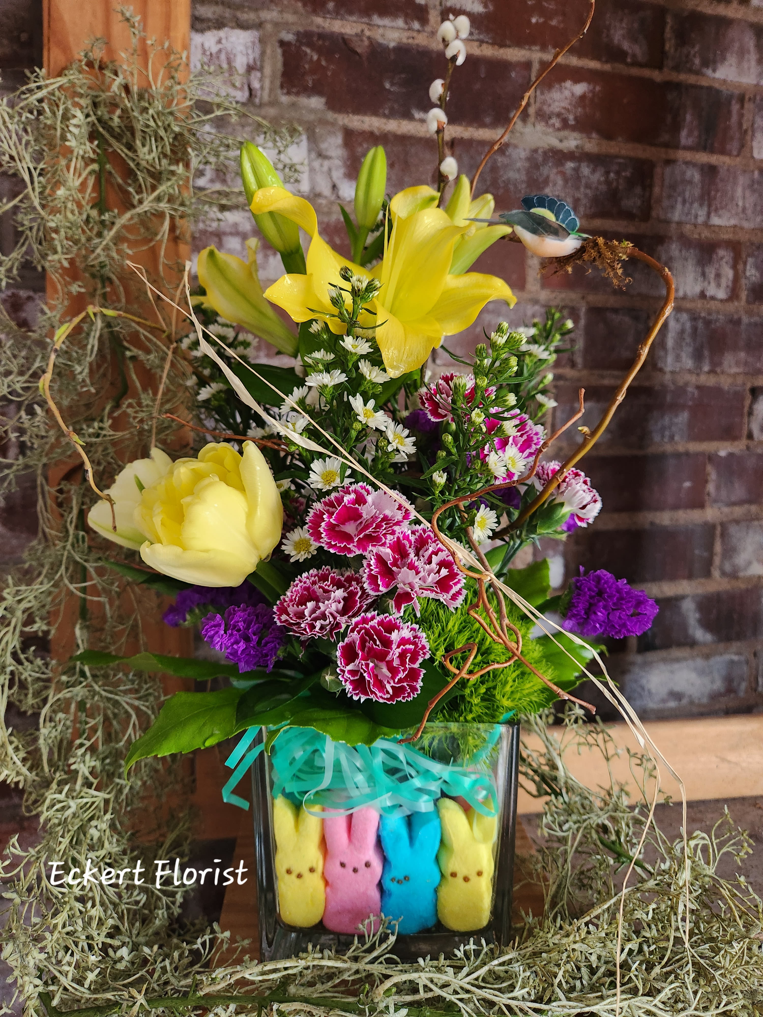 Eckert Florist's Peep of Spring Bouquet *Our Local Delivery Only - Want a fun and happy bouquet to send or to have for spring and/or Easter? This spring Peep bouquet will do the trick! Filled to the rim with marshmallow bunny peeps, this glass vase will arrive with the season's finest blooms. *Flowers and colors will vary