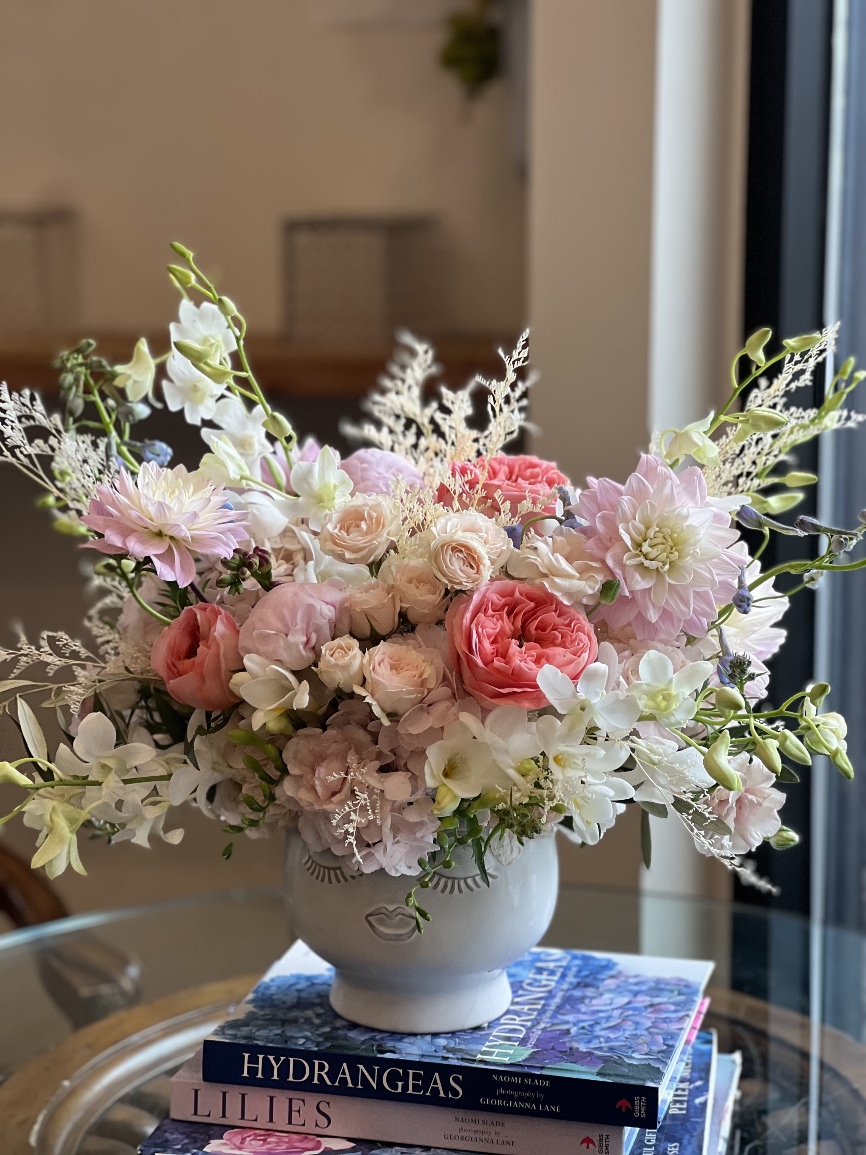 You Make Me Blush Arrangement - Flowers: pink x-pression garden roses, light pink peonies, blush majolica spray roses, pink dahlia's, white dendrobiums, misty white, lisianthus, blush hydrangea's, light blue delphinium, purple spotted phalaenopsis orchids, &amp; white freesias.  Vase: Large Face Planter 