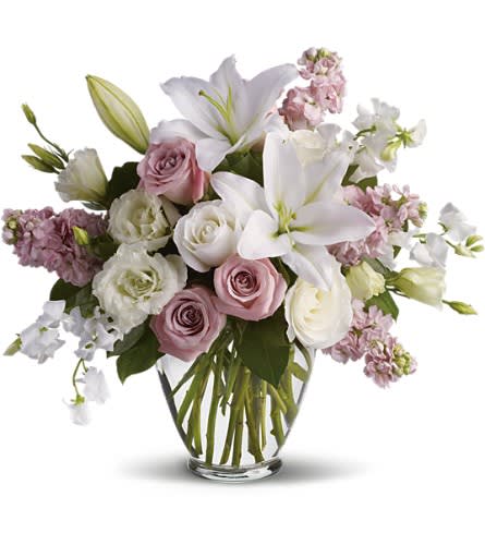 Isn't It Romantic - Tonight will certainly be romantic if you send this classic arrangement today! Beautiful hues and gorgeous blossoms will deliver your love. A stunning arrangement of light pink roses white roses lilies lisianthius and sweet pea plus pink stock make this one of our most desired selections.Approximately 19" W x 17 1/2" H Orientation: One-Sided As Shown : T9-1ADeluxe : T9-1BPremium : T9-1C