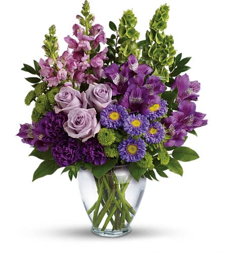Lavender Charm Bouquet - A soothing sea of lavender this beautiful bouquet blends luxurious roses and alstroemeria with playful snapdragons and bells of Ireland. It's a charming cheerful gift for any occasion! This lovely bouquet features lavender roses purple alstroemeria purple carnations lavender matsumoto asters green button spray chrysanthemums lavender snapdragons bells of Ireland huckleberry and lemon leaf. Delivered in a clear glass vase.Approximately 14 1/2" W x 17 1/2" H Orientation: One-Sided As Shown : TEV42-3ADeluxe : TEV42-3BPremium : TEV42-3C