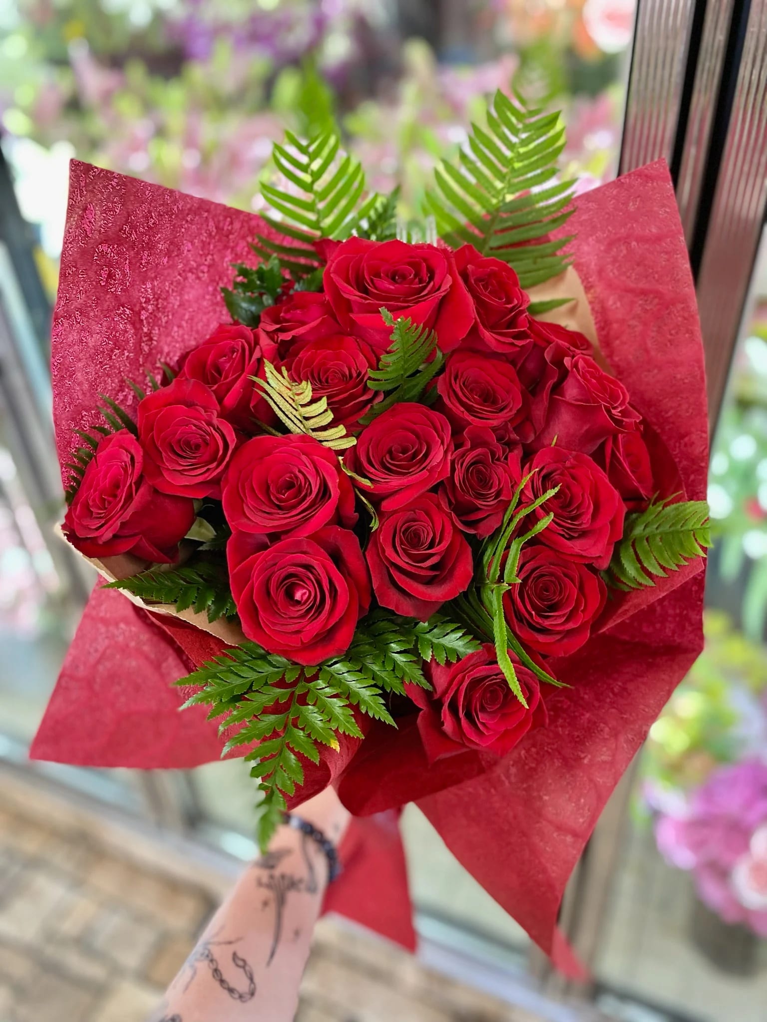 18 Red Roses Wrapped - A classy wrapped bouquet with 18 red roses and greenery.  Just to let you know, wrap colors may vary but we do our best to match the arrangement shown.