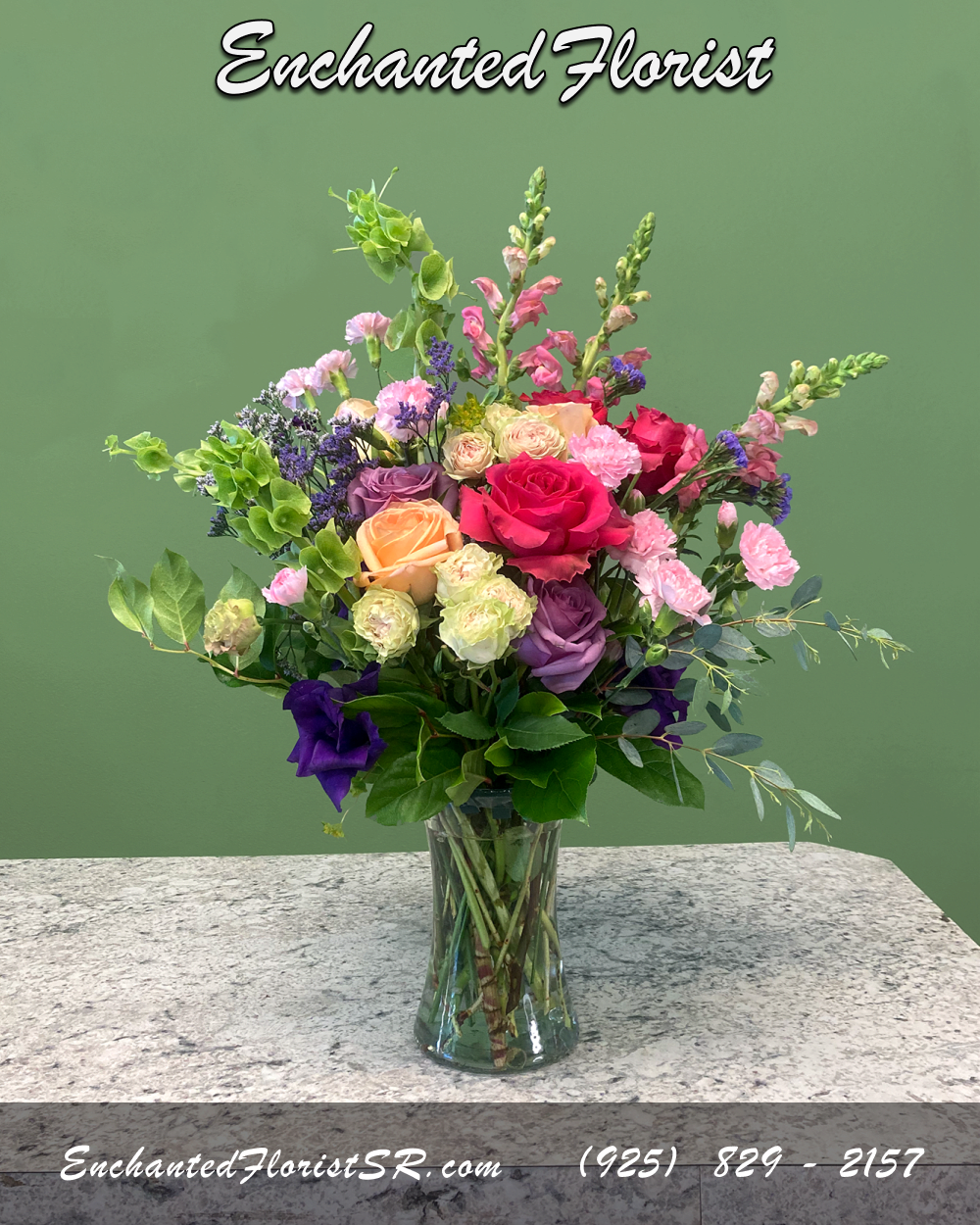 Lovely Day - Mixed Arrangement - A charming mixed arrangement that showcases vibrant colors. Featuring roses, carnations, garden roses, snapdragons, and lisianthus. Accented with statice, 'Bells of Ireland', lush lemon leaf, and various other greens. Presented in a stylish glass 'Gathering' vase.   Perfect for celebrating special occasions, adding a touch of natural beauty to any space, or expressing heartfelt sentiments to someone special.  Arrives In: Clear glass 'Gathering' vase  Orientation: One-Sided  Approximate Dimensions: 18" Tall 14" Wide 5" Vase Diameter