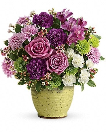 Spring Speckle Bouquet - Inspired by Japanese pottery, this hand-speckled, hand-glazed stoneware pot is a splendid spring gift--especially when filled with a lush lavender bouquet! Lavender roses, purple alstroemeria, purple carnations, white miniature carnations, green cushion spray chrysanthemums, and lavender cushion spray chrysanthemums are accented with pink waxflower and variegated pittosporum. Delivered in a Spring Speckle Pot. 