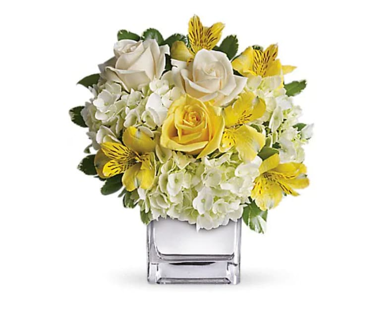 Sweetest Sunrise Bouquet - Fresh as an April morning, this cheerful array of yellow roses, crème roses and other favorites in a sparkling silver cube vase will be an instant favorite. Who could resist its sunny charms? The bright bouquet includes white hydrangea, light yellow roses, crème roses and yellow alstroemeria accented with fresh greenery. Delivered in a contemporary glass cube with a mirrored silver finish.   Orientation : One-Sided  All prices in USD ($)  Standard  T403-3A  Deluxe  T403-3B  Premium  T403-3C
