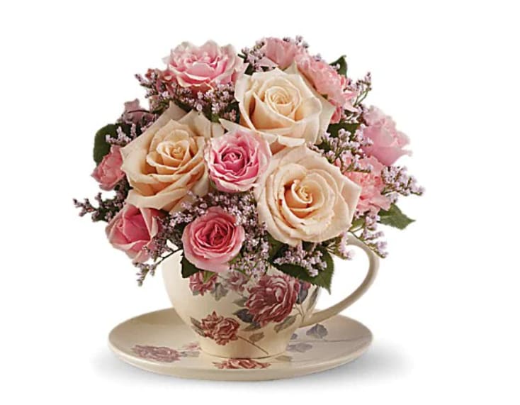 Victorian Teacup Bouquet - Send comfort to the recently bereaved with this sweet sympathy flower arrangement. This charming, old-fashioned bouquet features pink roses in a floral teacup. Cream roses, pink spray roses, miniature pink carnations and delicate pink limonium are presented in a teacup and saucer with a Victorian flower pattern.   Orientation : One-Sided  All prices in USD ($) 