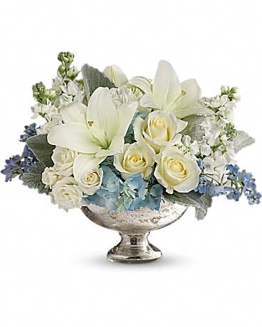 Elegant Affair Centerpiece - As magical and unforgettable as an elegant affair! Creamy roses and snow white lilies are accented with whisper blue blooms in this regal arrangement, hand-delivered in a classic silver mercury glass bowl. An impressive, elegant choice no matter the occasion. This elegant mix includes light blue hydrangea, white roses, white spray roses, white asiatic lilies, white carnations, light blue delphinium, white stock and dusty miller. Delivered in a silver mercury glass bowl. 