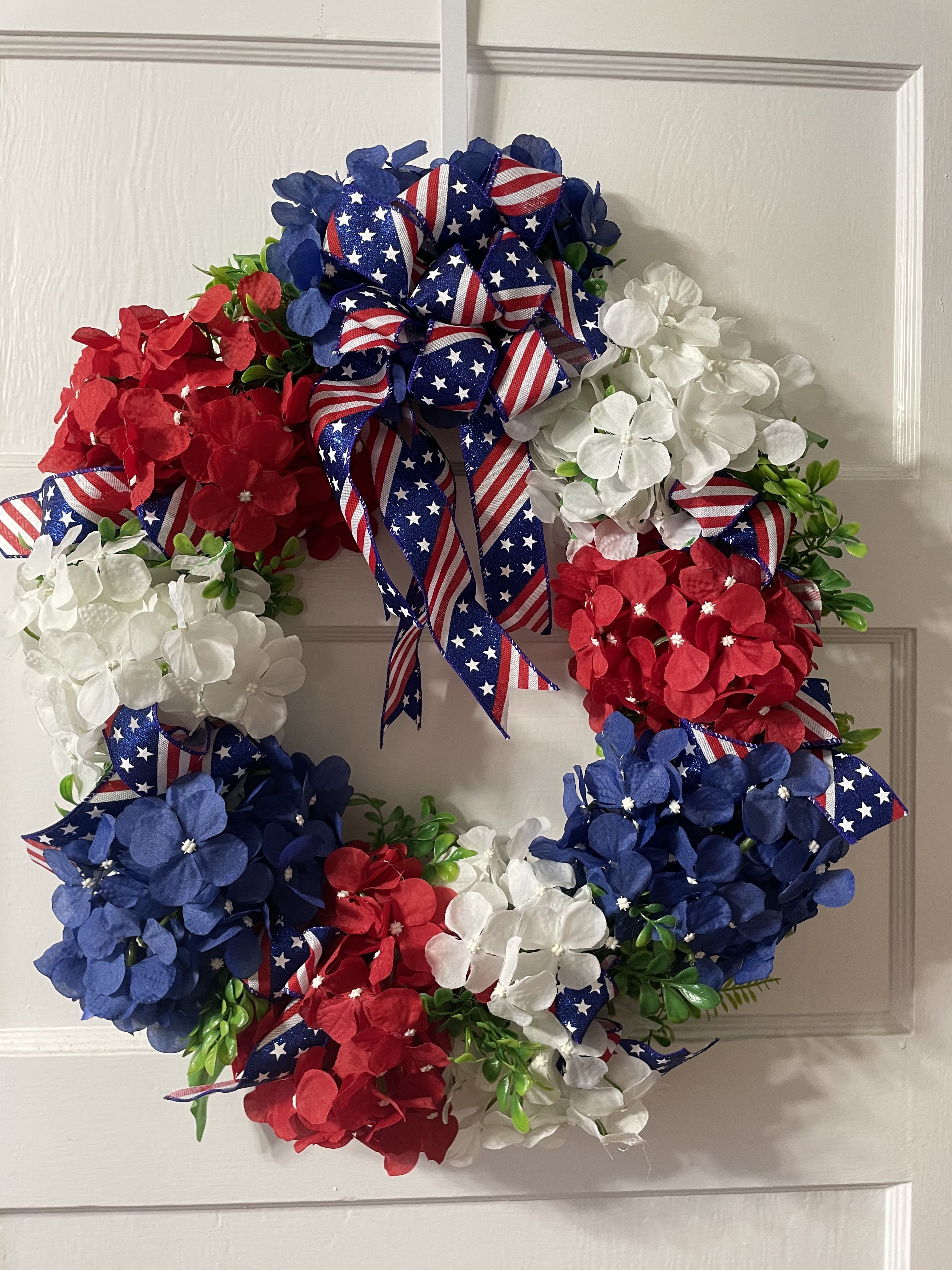 Patriotic Silk Grapevine Wreath - Silk wreath in red, white, and blue. This is a medium to large sized, grapevine wreath with red, white, and blue silk flowers, and greens. Will be delivered on a stand for services.