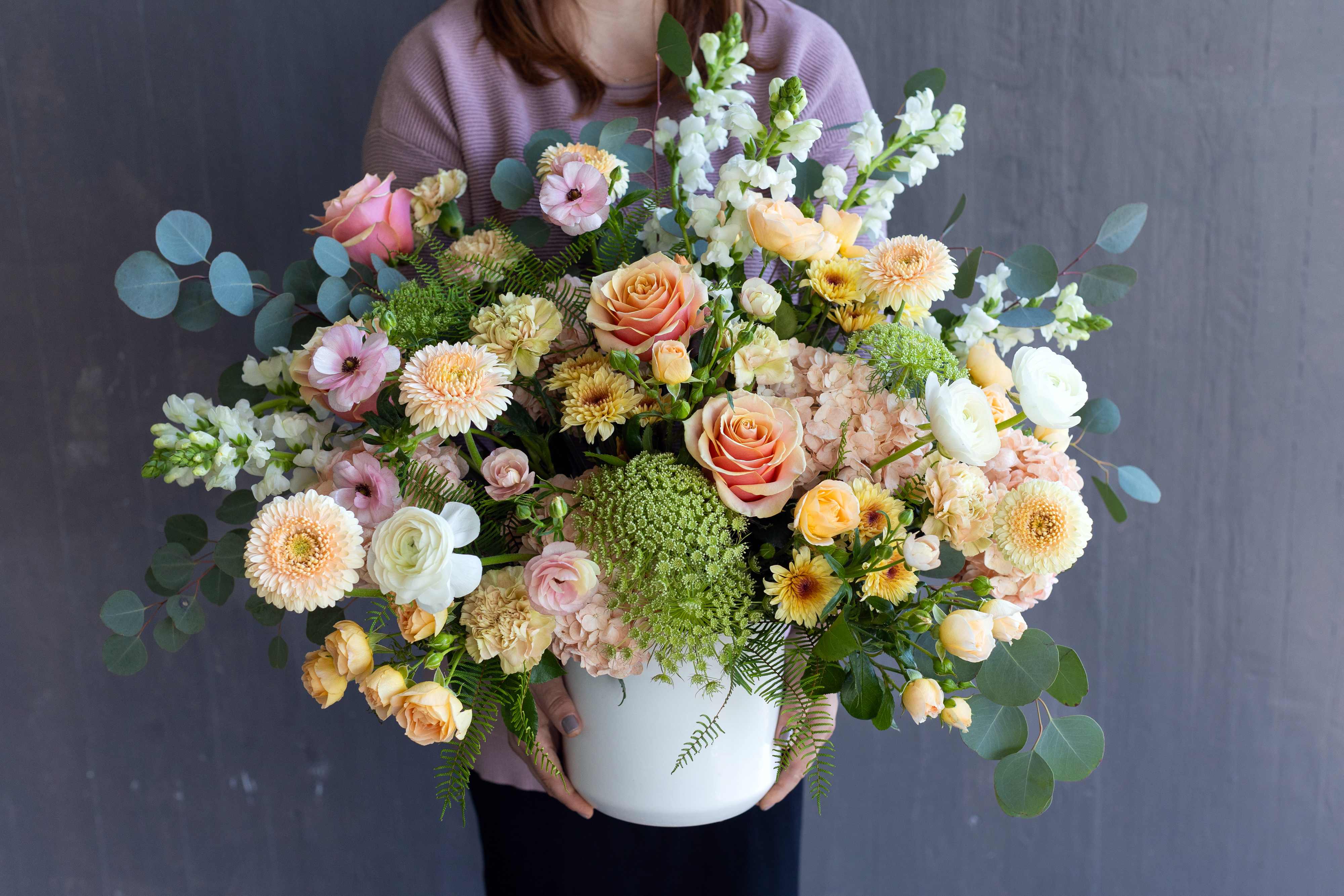 Peach Sorbet- The Signature Collection - This melody of roses, hydrangeas, and ranunculus creates a delicious and creamy dessert for the eyes. Pale pink, white, and peach florals burst from the vase with passion and grace. A perfectly light and feminine arrangement to brighten any home.   This arrangement is offered as part of our Signature Collection. Due to the nature and scale of this design, we cannot offer same day delivery on any of our Signature Collection designs. We want to ensure the finest designs, and take care to ensure each arrangement is crafted with the highest quality flowers. Although we strive to create each arrangement as close to our photos as possible, there is always the chance that some flowers may be seasonally unavailable. In this case, we would substitute with flowers of a similar look and quality, without sacrificing the value of the design. Each arrangement will adhere to the color pallet and look of the arrangement ordered.     SIZE: This flower arrangement is approximately 20” height and 20” width.  FAQ Q: What time will my flowers arrive? A: Excellent question! For full details around our delivery process and timings, please see our Terms and Conditions. Q: May I request to change the design a bit? A: Yes, please make a note in the SPECIAL INSTRUCTION box when you place your online order. We will do our best to follow them. 