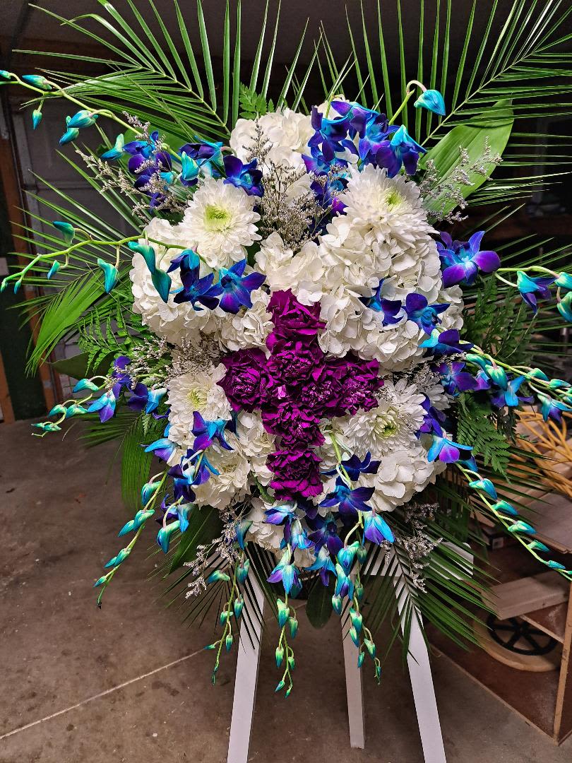 Heaven's Whisper - Sympathy spray made up of hydrangea, orchids, and a cross made of carnations.
