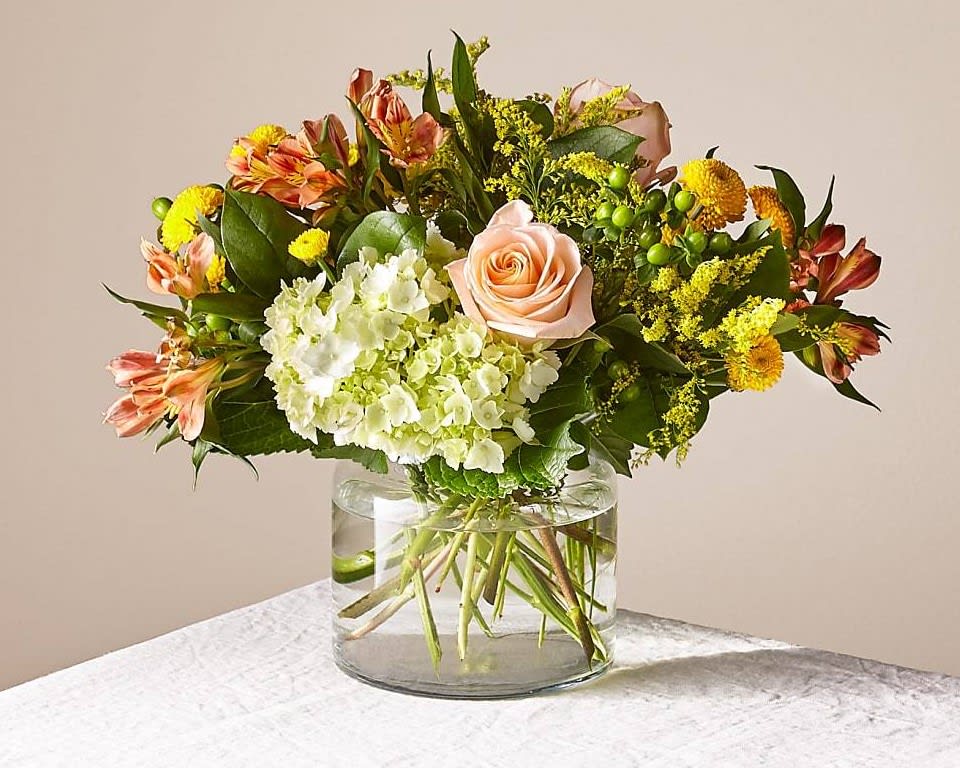 Life's a Peach - This radiant bouquet is designed with a dreamy mix of peach, yellow, and light green blooms to create the perfect impression. Whether it's sent as a pick–me–up, a celebration, or just to make someone smile, everything is just peachy once this arrangement arrives.