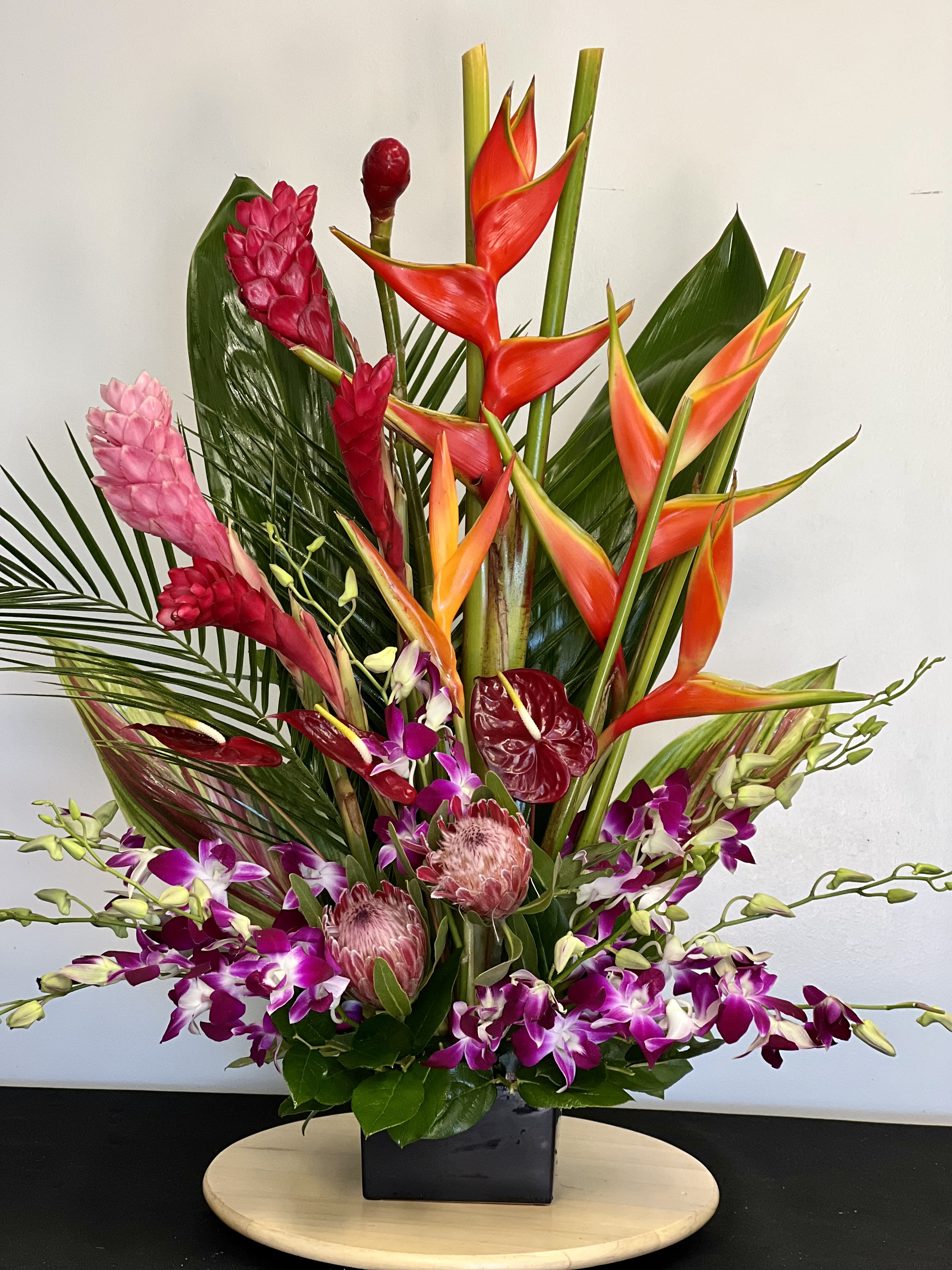 Vision of Beauty (53) - Head to the tropics with this spectacular and exotic display of orchids, birds of paradise, glossy anthurium and more, artfully arranged in a towering arrangement that will transform any room into an island paradise.