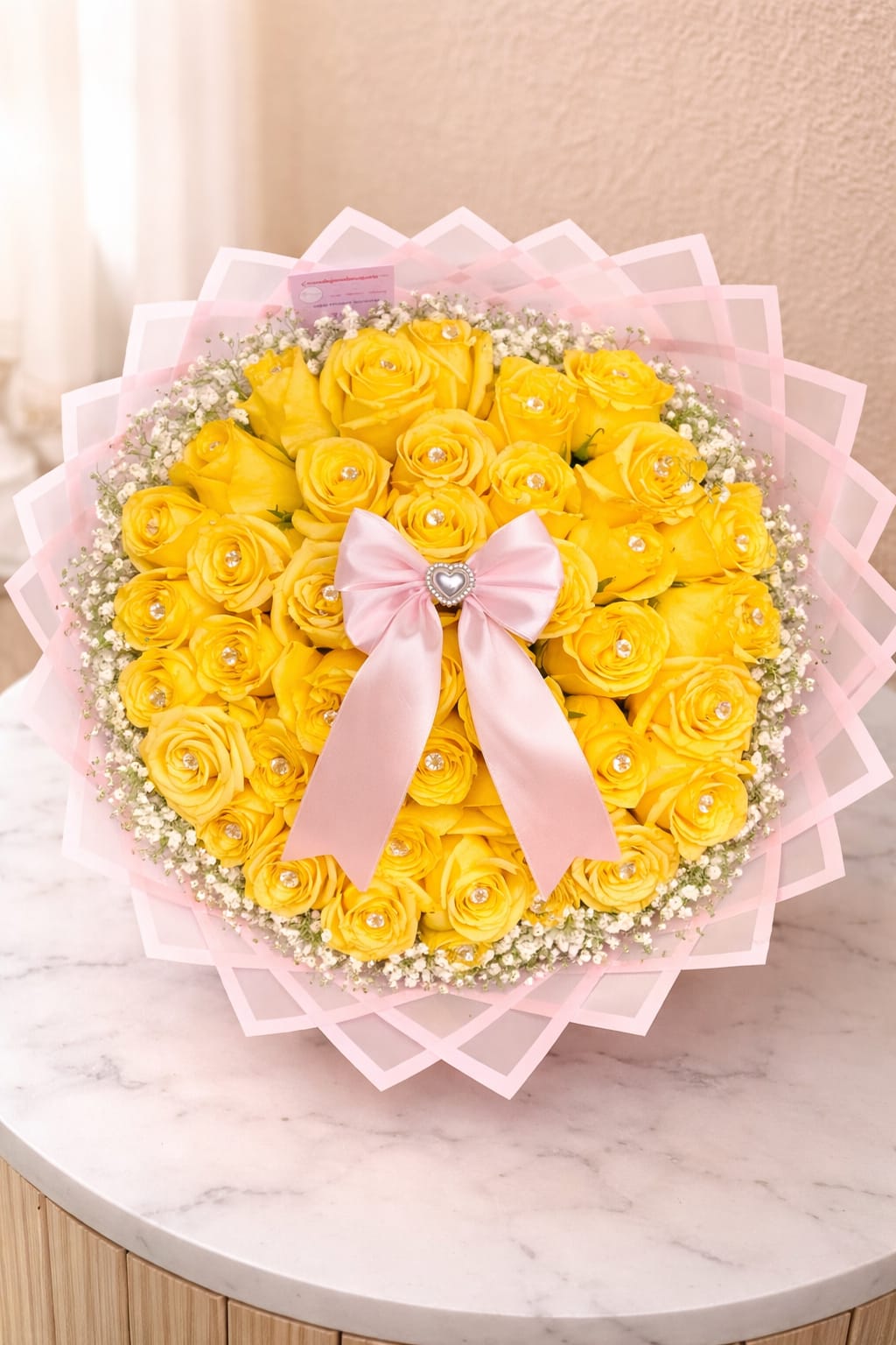 Bouquet of yellow roses with a pink ribbon and baby’s breath