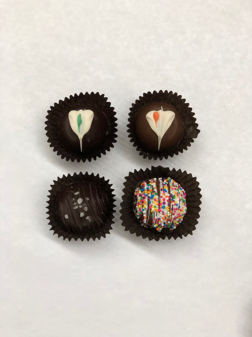 4 pc MG Assorted Truffles - LOCAL DELIVERY OR PICK UP ONLY - An assortment of 4 chocolate truffles in a box.   Allergy Information: Equipment is shared with products that may contain peanuts, tree nuts, milk, soy, wheat, red, yellow and blue food coloring.
