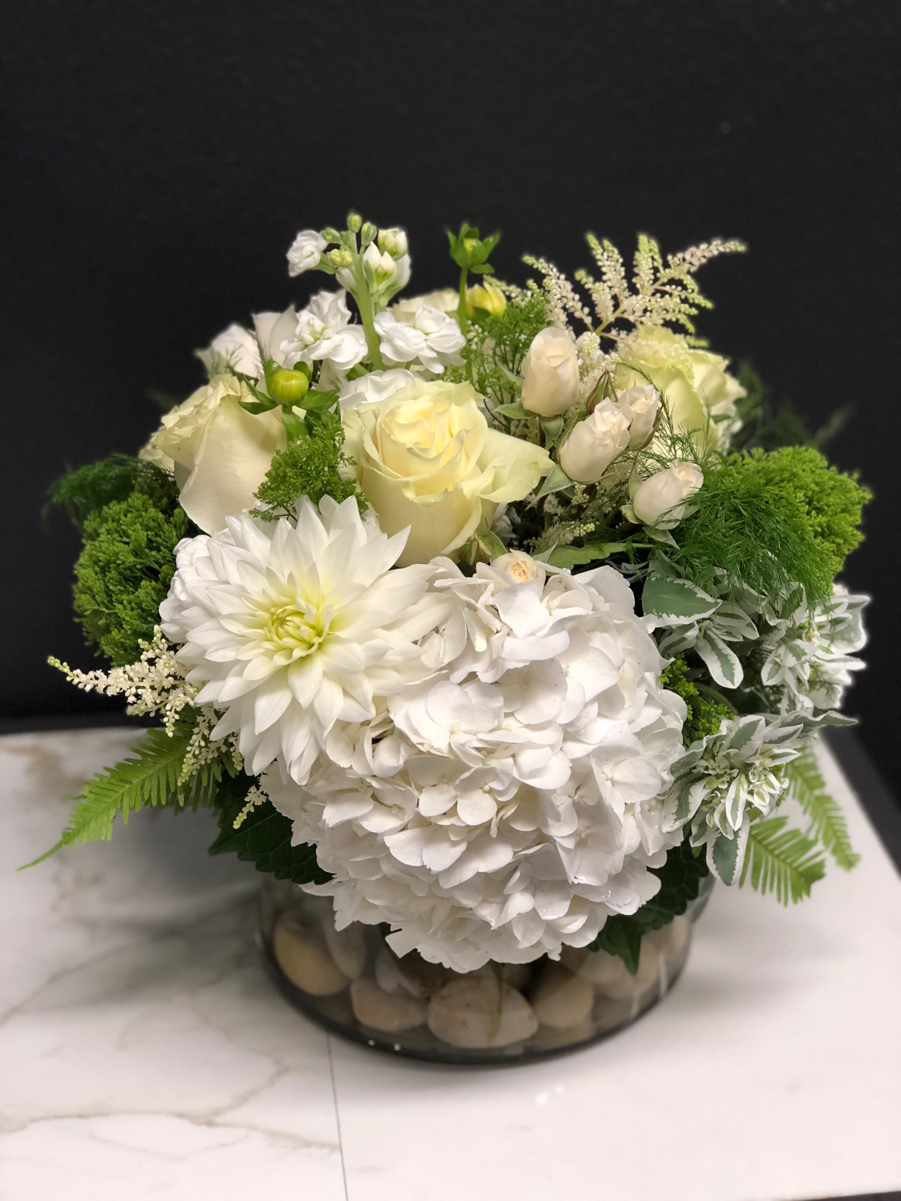 Lush Creamy Seasonal Garden  - An elegant seasonal garden mix in creamy whites and greens. Arranged low and dense in our signature English garden style. Delivered in a clear glass vase. Floral varieties may vary but will be of similar quality and style. Overall design is approximately 13" x 13" in the standard size. 
