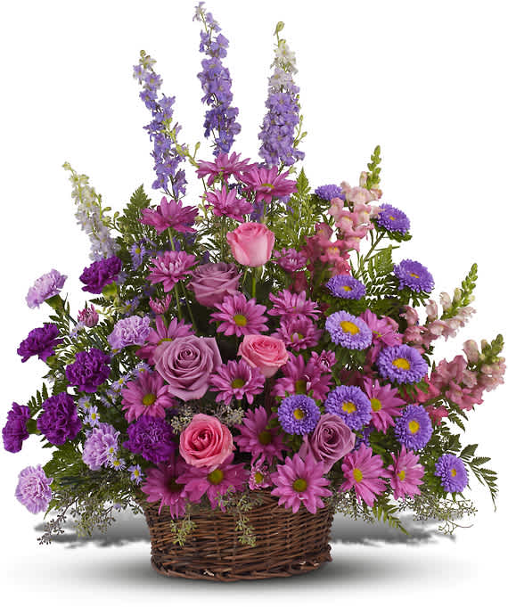 GRACIOUS LAVENDER BASKET - Soothing jewel tones of lavender, purple and pink come together to celebrate a life and comfort friends and loved ones - an abundant basket of fragrant country blooms that pays tribute to someone truly special.  Purple, pink and lavender petals abound in a lovely mix of flowers such as roses, carnations, snapdragons, larkspur, matsumoto and monte cassino asters, nestled among leatherleaf fern and eucalyptus in a round wicker basket.