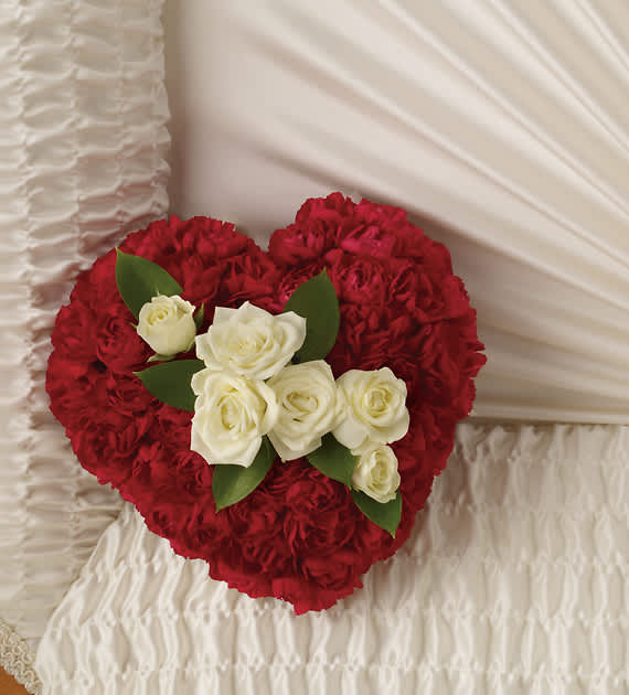 A DEVOTED HEART CASKET INSERT - Delicate white roses enclosed in a heart made of red carnations is a promise that the departed will always be remembered with a deep and abiding love.  