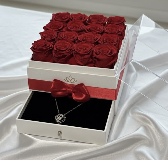 Classic Red Preserved Rose Jewelry Drawer Box – 16 Roses Luxury Gift Set - Our Classic Red Preserved Rose Jewelry Drawer Box – 16 Roses Luxury Gift Set features sixteen premium preserved red roses carefully arranged in a modern square luxury box with a satin ribbon detail and integrated drawer compartment.  Designed to combine floral elegance with jewelry presentation, this refined gift set includes a lower drawer space ideal for a necklace or small keepsake, making it perfect for anniversaries, romantic surprises, birthdays, and Valentine’s Day.  The timeless red roses symbolize love, passion, and devotion. Unlike fresh flowers, preserved roses maintain their natural beauty for months — even years — with proper care, creating a meaningful and lasting impression.  Its compact yet sophisticated design makes it a premium statement gift for intimate celebrations. 