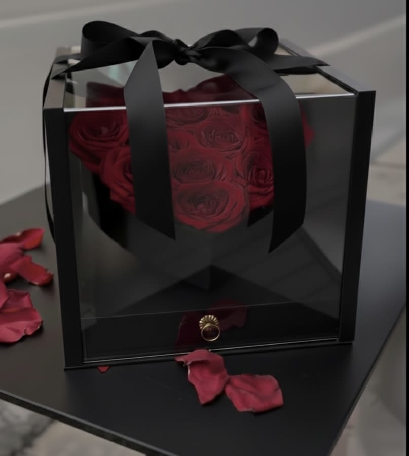 Luxury Rose Heart Box with Chocolates - The Luxury Rose Heart Box with Chocolates is a refined and unforgettable floral gift designed for meaningful occasions.  This arrangement features fresh premium red roses beautifully arranged in a heart-shaped box, enclosed inside a modern black acrylic display case for an elevated presentation.  The base includes a hidden drawer filled with assorted premium chocolates, creating a complete luxury experience in one elegant piece.  Perfect for anniversaries, romantic celebrations, proposals, birthdays, or special surprises, this design combines elegance, depth, and indulgence.  Crafted with attention to detail, this piece is designed to make a lasting impression.