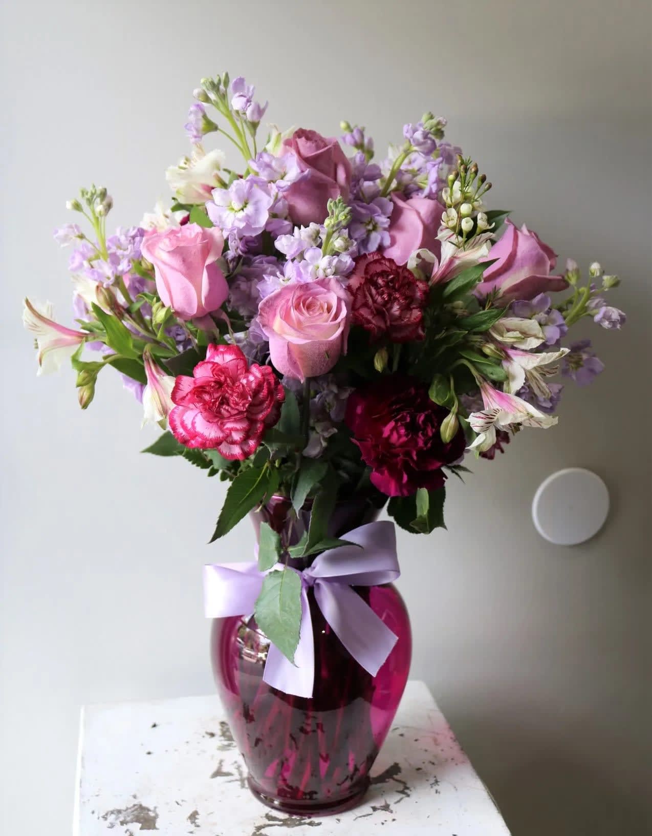 Purple Celebration - An elegant arrangement of Lavender Roses, Stocks, mixed carnations and white alstroemerias 