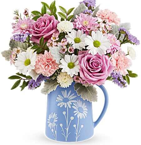 Teleflora's Pastel Meadow Bouquet - Soft and serene, Teleflora's Pastel Meadow Bouquet brings the beauty of a blossoming garden indoors with delicate lavender roses and pastel blooms arranged in a blue food-safe pitcher featuring a charming white daisy design.